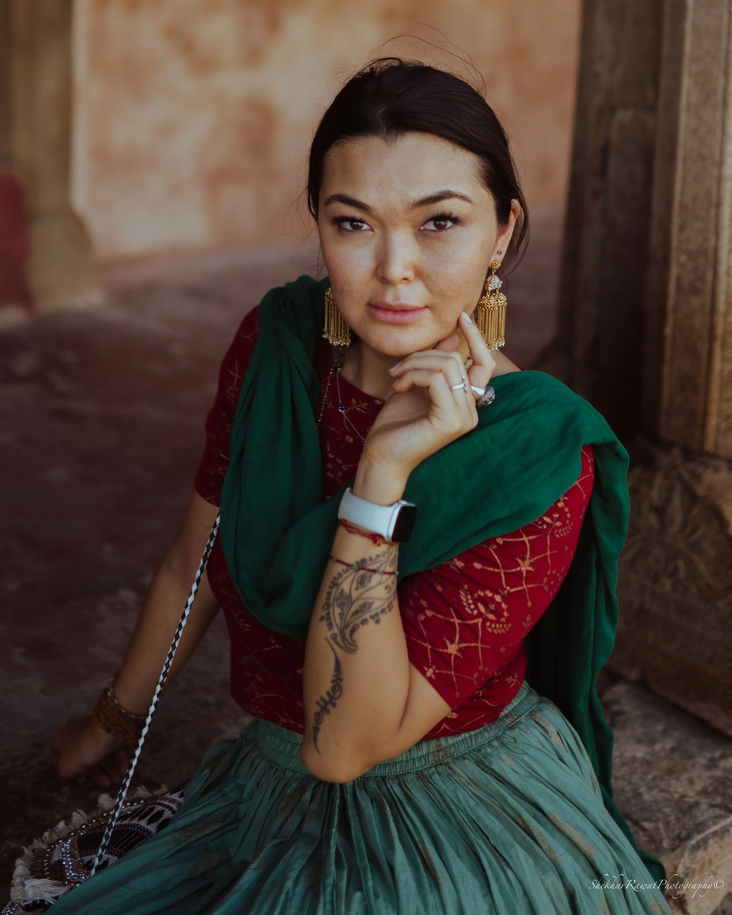 Woman in gold earrings, a red embroidered top and green shawl, traditional Indian portrait by Melbourne photographer Shekhar Rawat