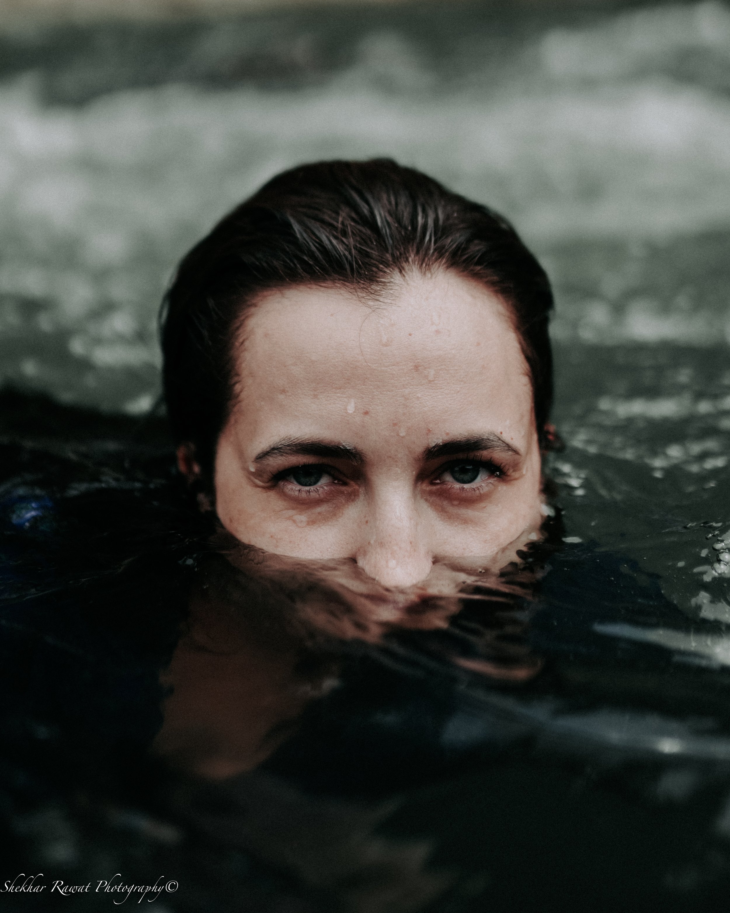 Face half-submerged in water with droplets, creative water portrait by Melbourne photographer Shekhar Rawat