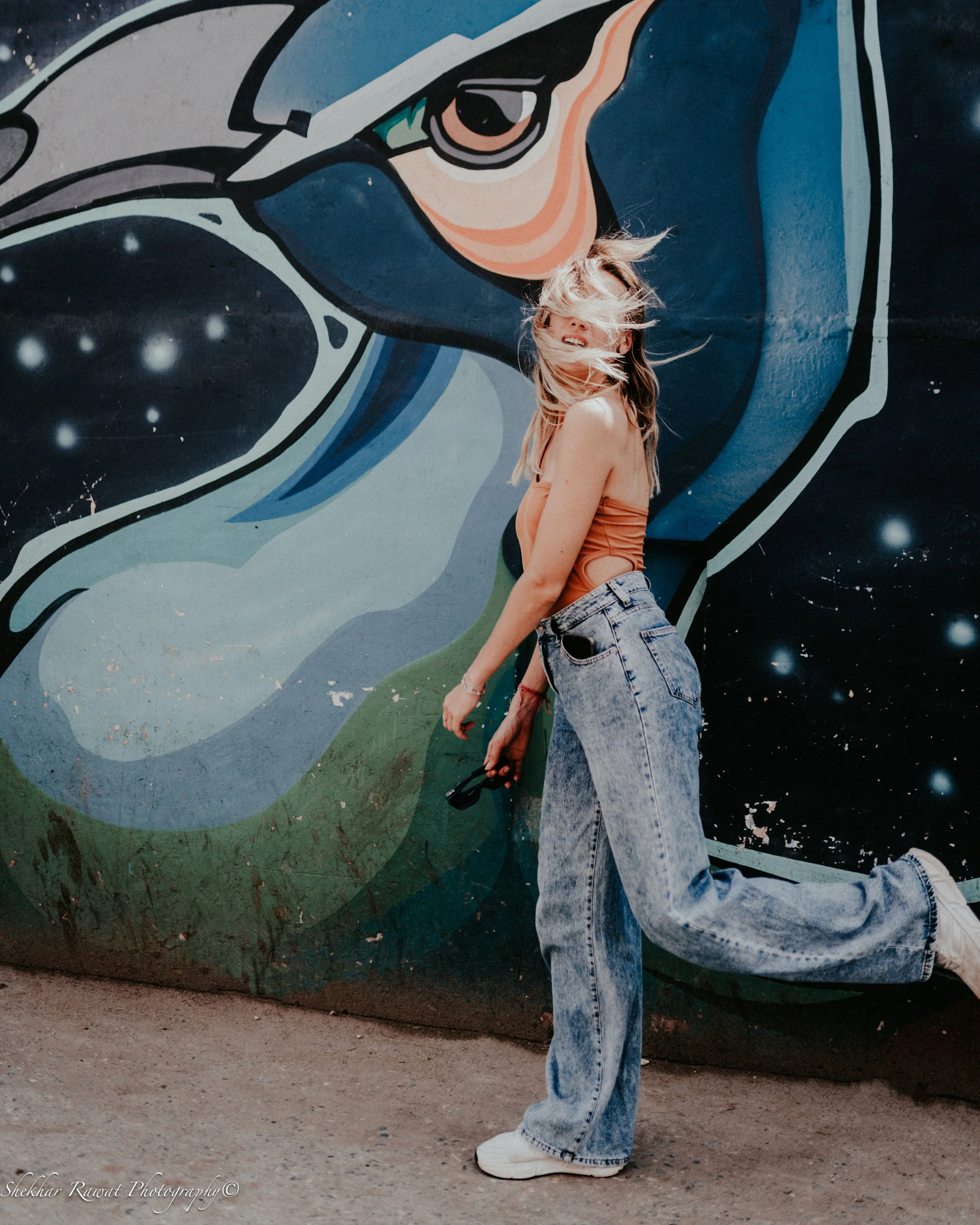Model with a camera in front of a colourful street-art mural, street style fashion shoot in Melbourne by Shekhar Rawat