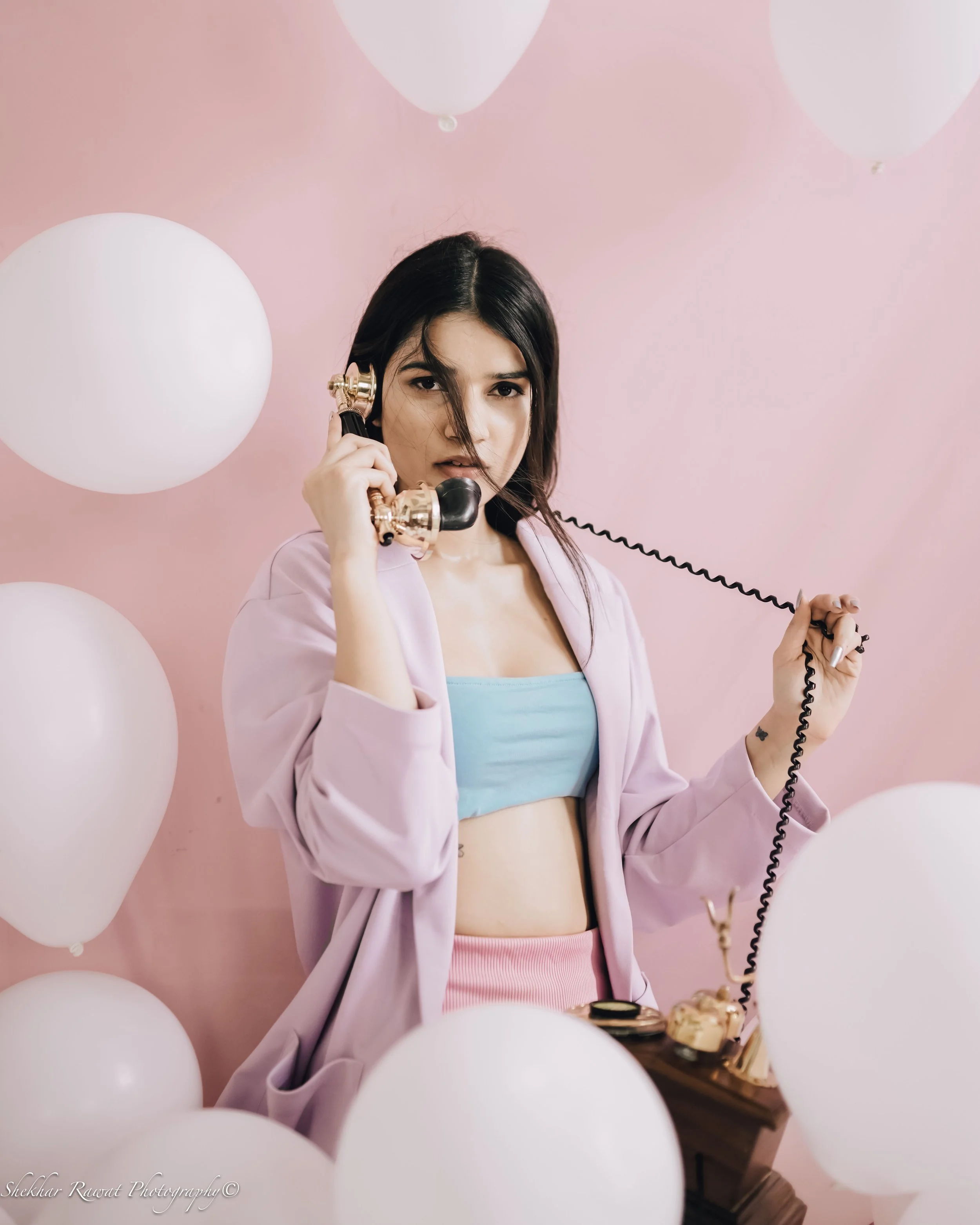 Model with a vintage telephone and white balloons against a pink wall, creative studio shoot in Melbourne by Shekhar Rawat
