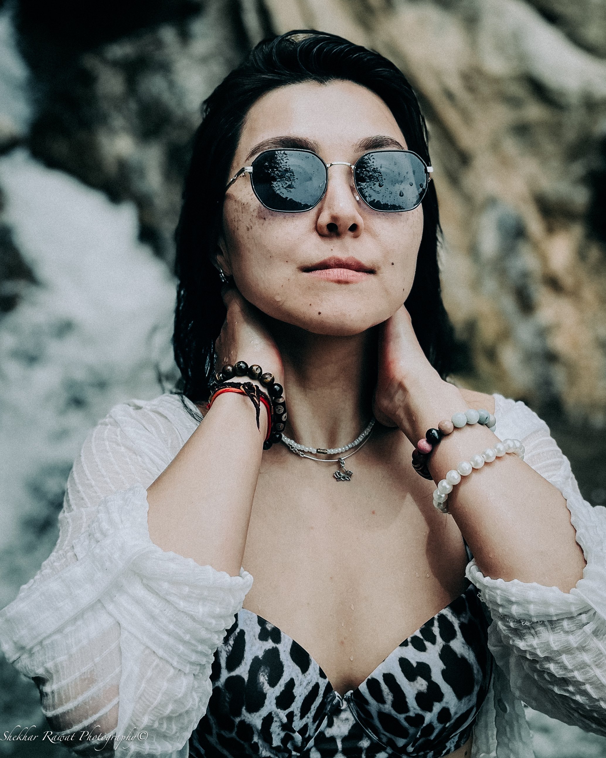Smiling woman in sunglasses and a white off-shoulder top by the water, lifestyle portrait by Melbourne photographer Shekhar Rawat