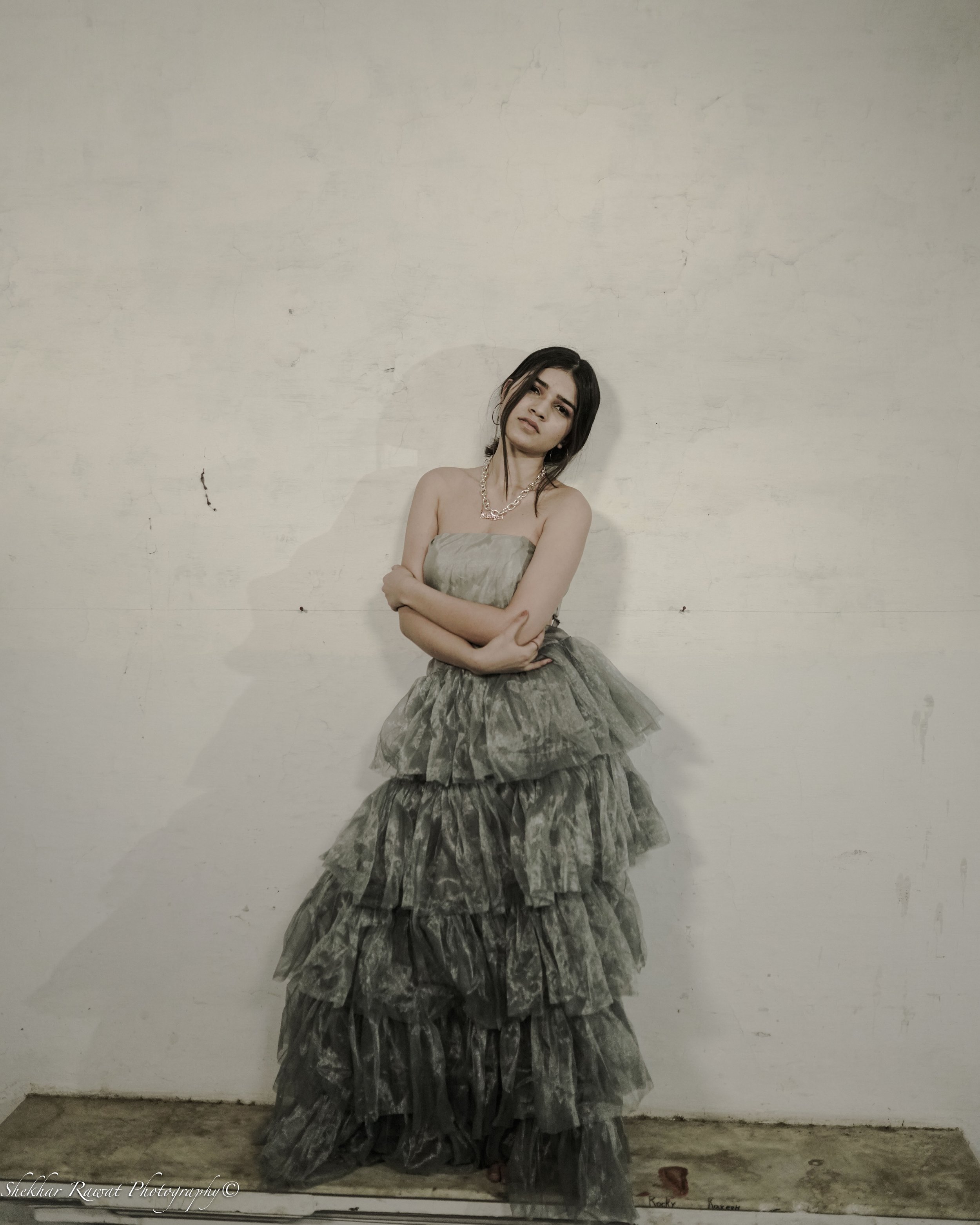 Model in a grey ruffled strapless dress against a white wall, studio fashion photography in Melbourne by Shekhar Rawat