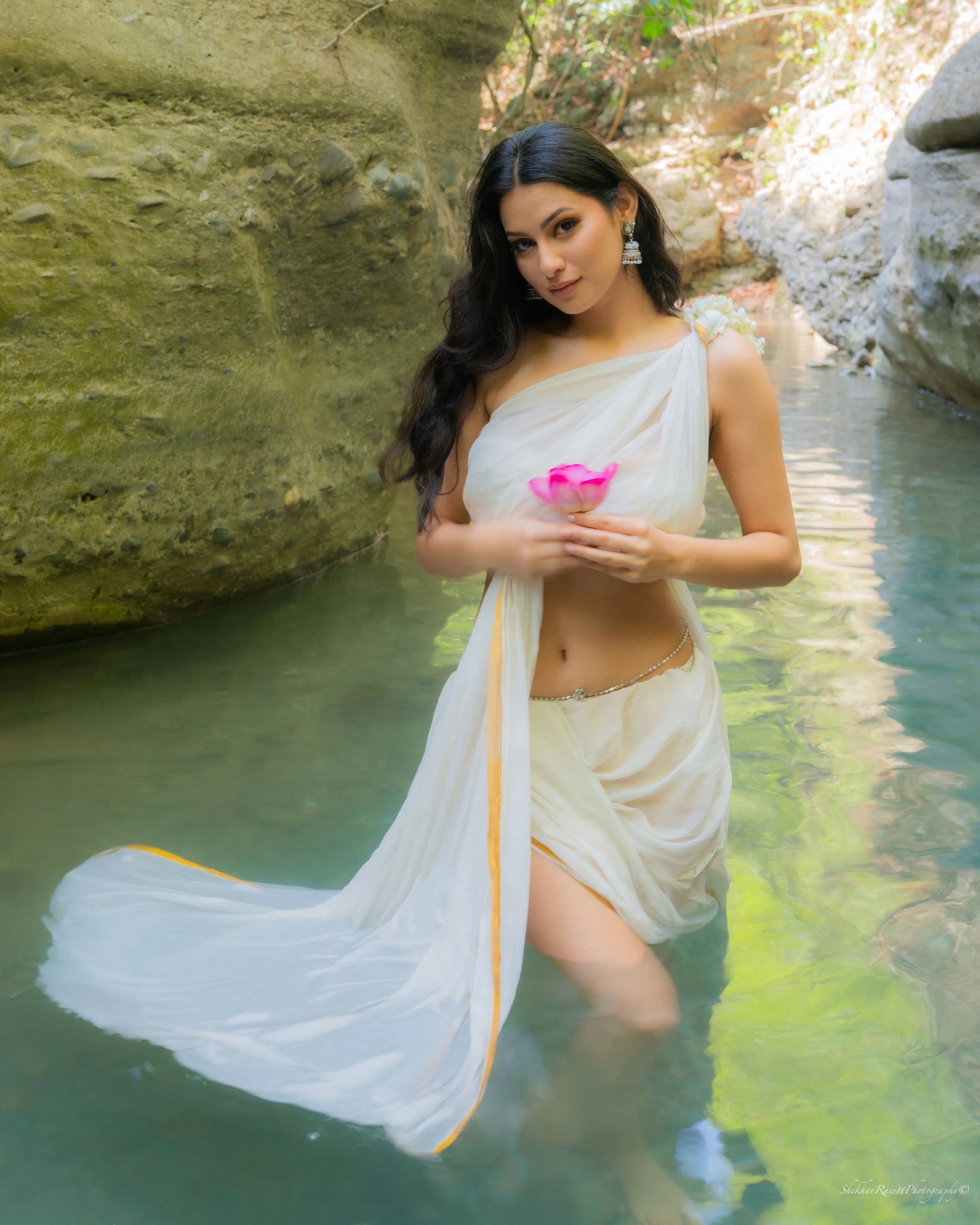 Model in traditional white attire holding a pink lotus in water, conceptual Indian fashion shoot by Melbourne photographer Shekhar Rawat