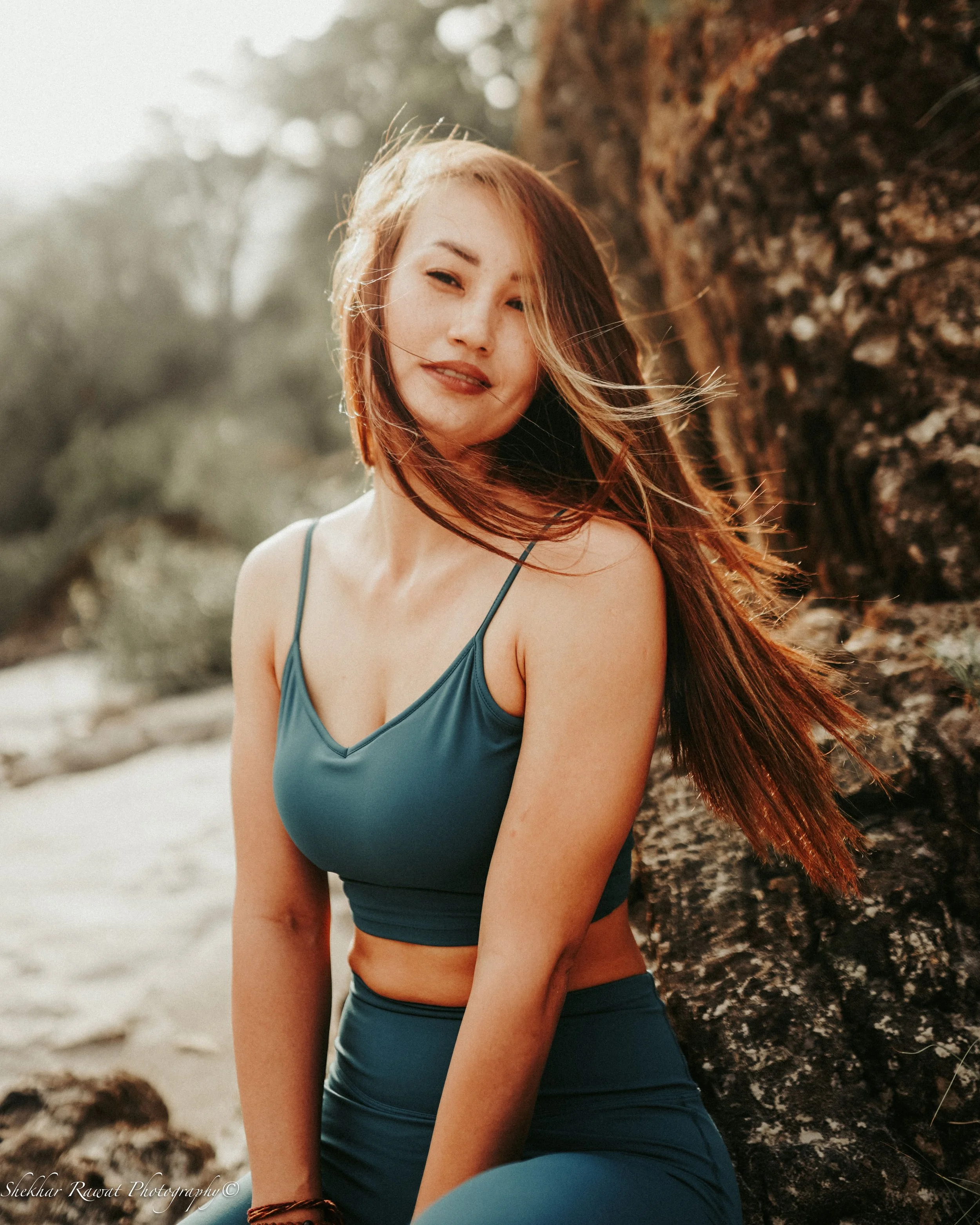 Smiling woman in a teal top in warm sunlight, natural portrait photography by Melbourne photographer Shekhar Rawat