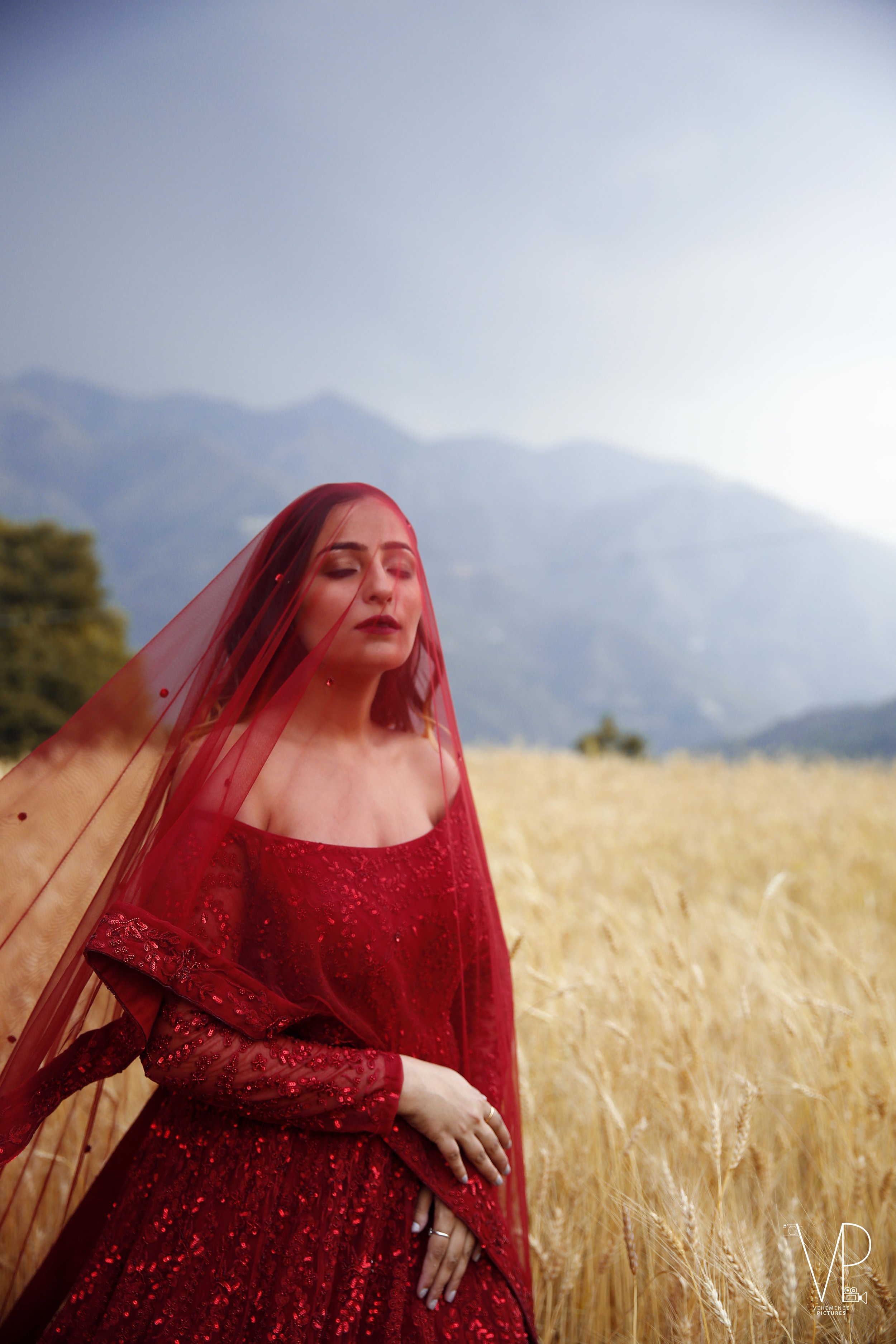 Model in a red dress and veil in a golden wheat field, fashion shoot by Melbourne photographer Shekhar Rawat
