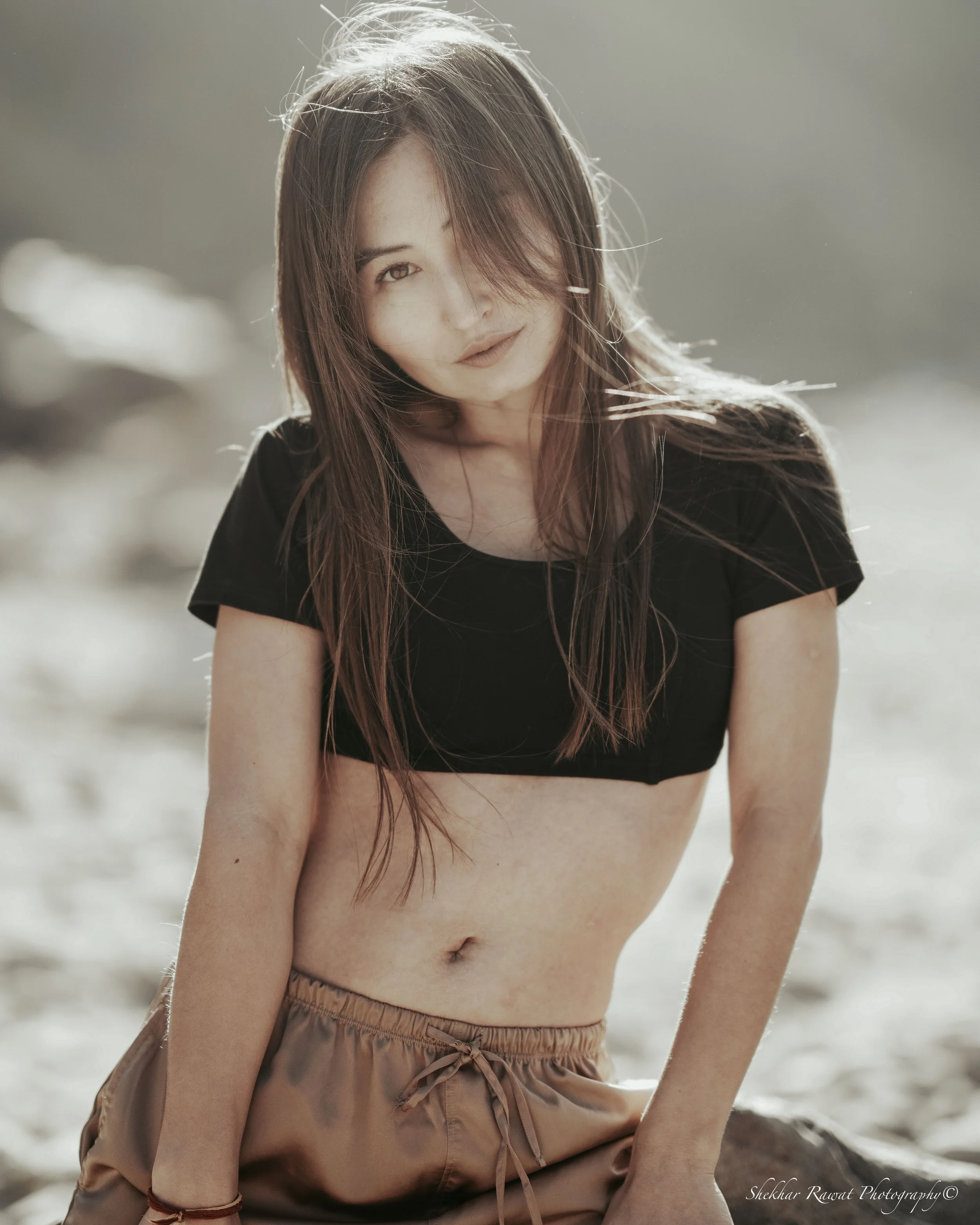 Model sitting on a beach rock in golden sunlight, lifestyle fashion shoot by Melbourne photographer Shekhar Rawat