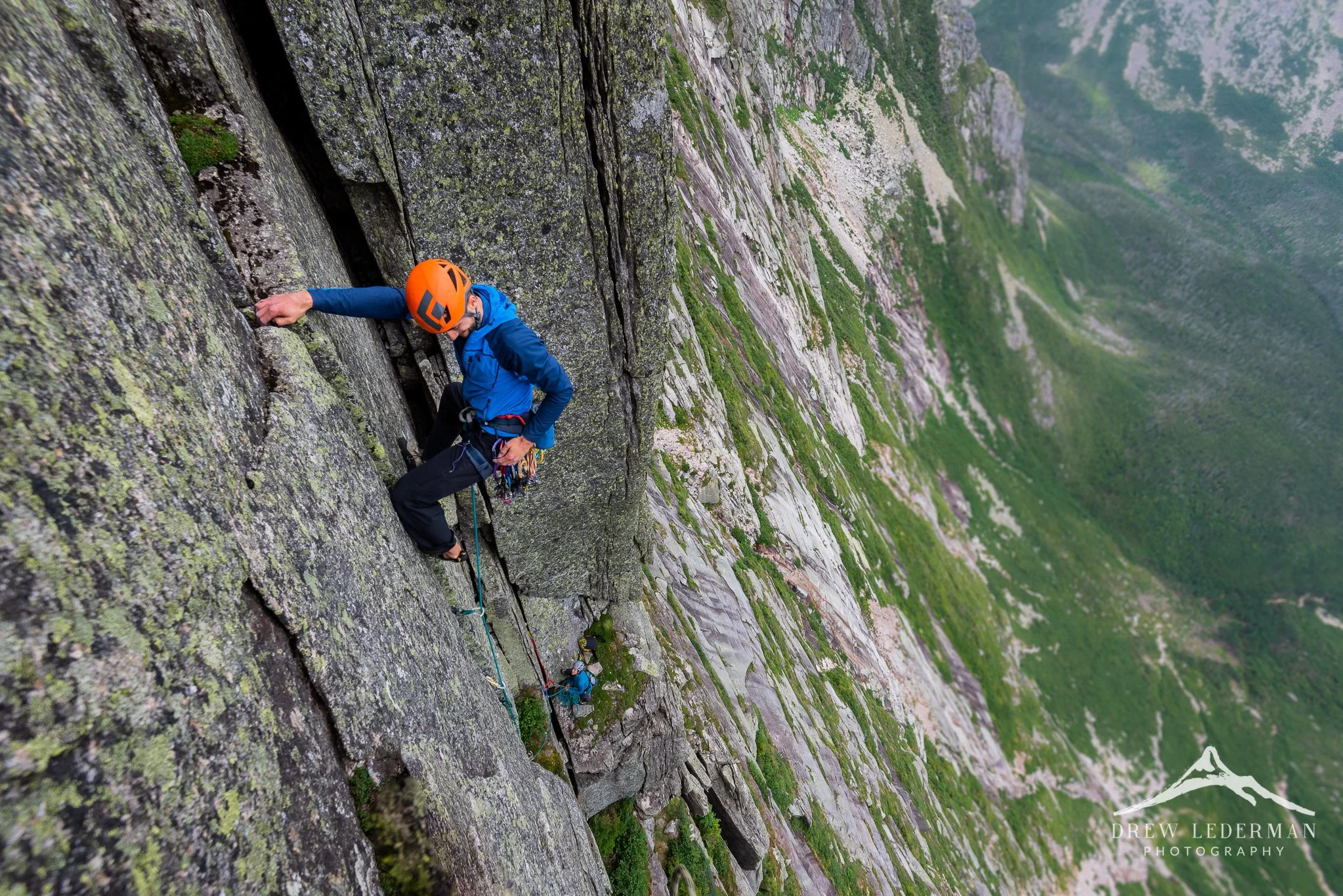 A mountain climber scales a rock face.