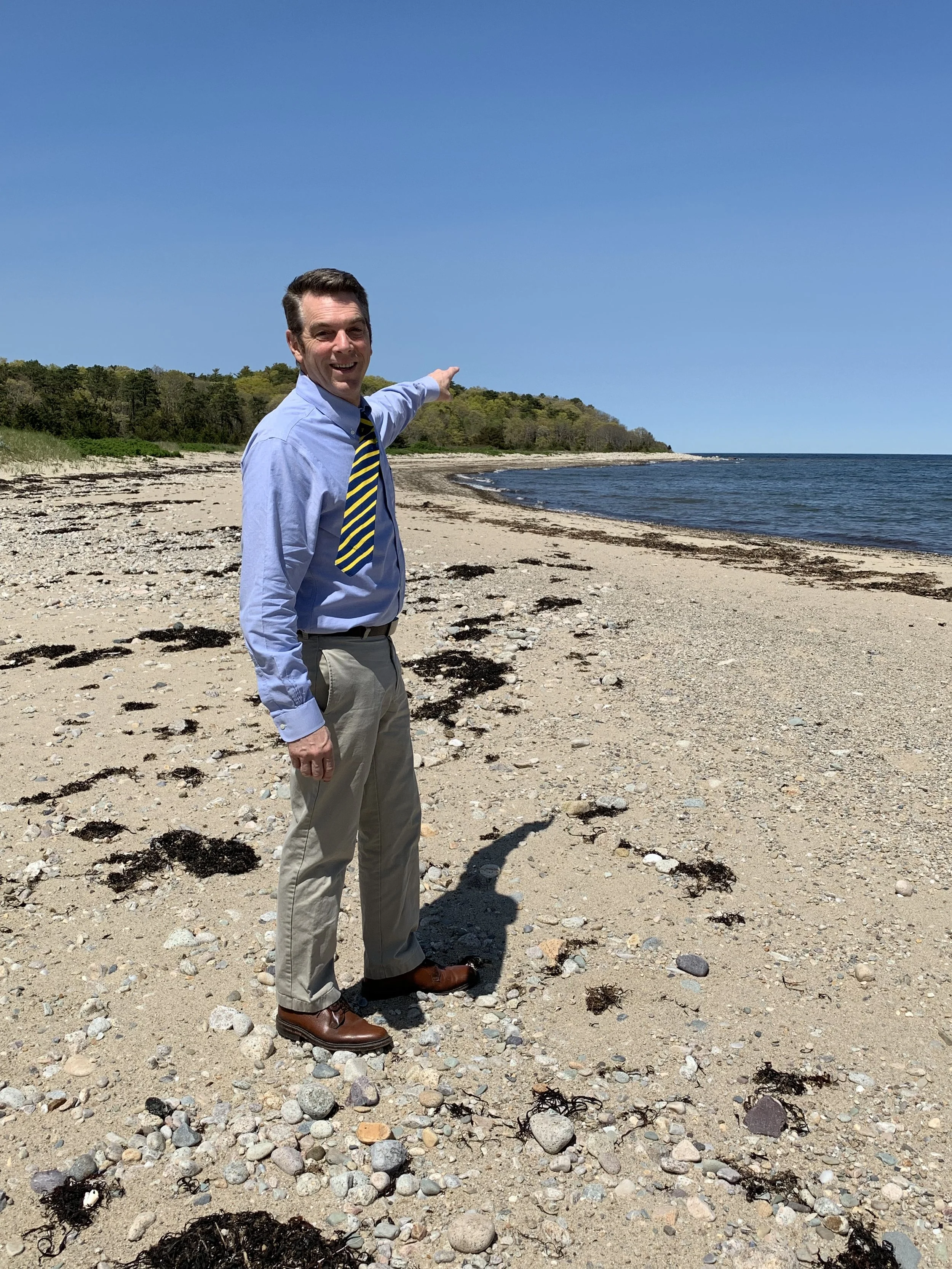 Bill Keohan standing and pointing out at the water at Center Hill Preserve
