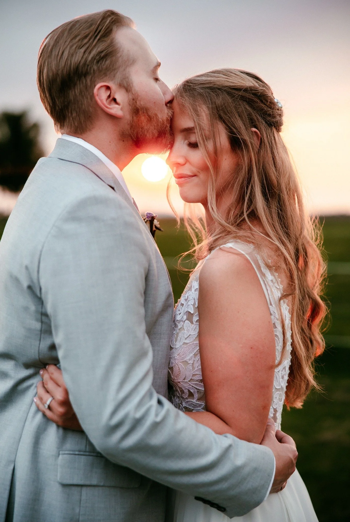 Bride and groom embracing in warm sunset light, romantic wedding portrait in London Ontario.