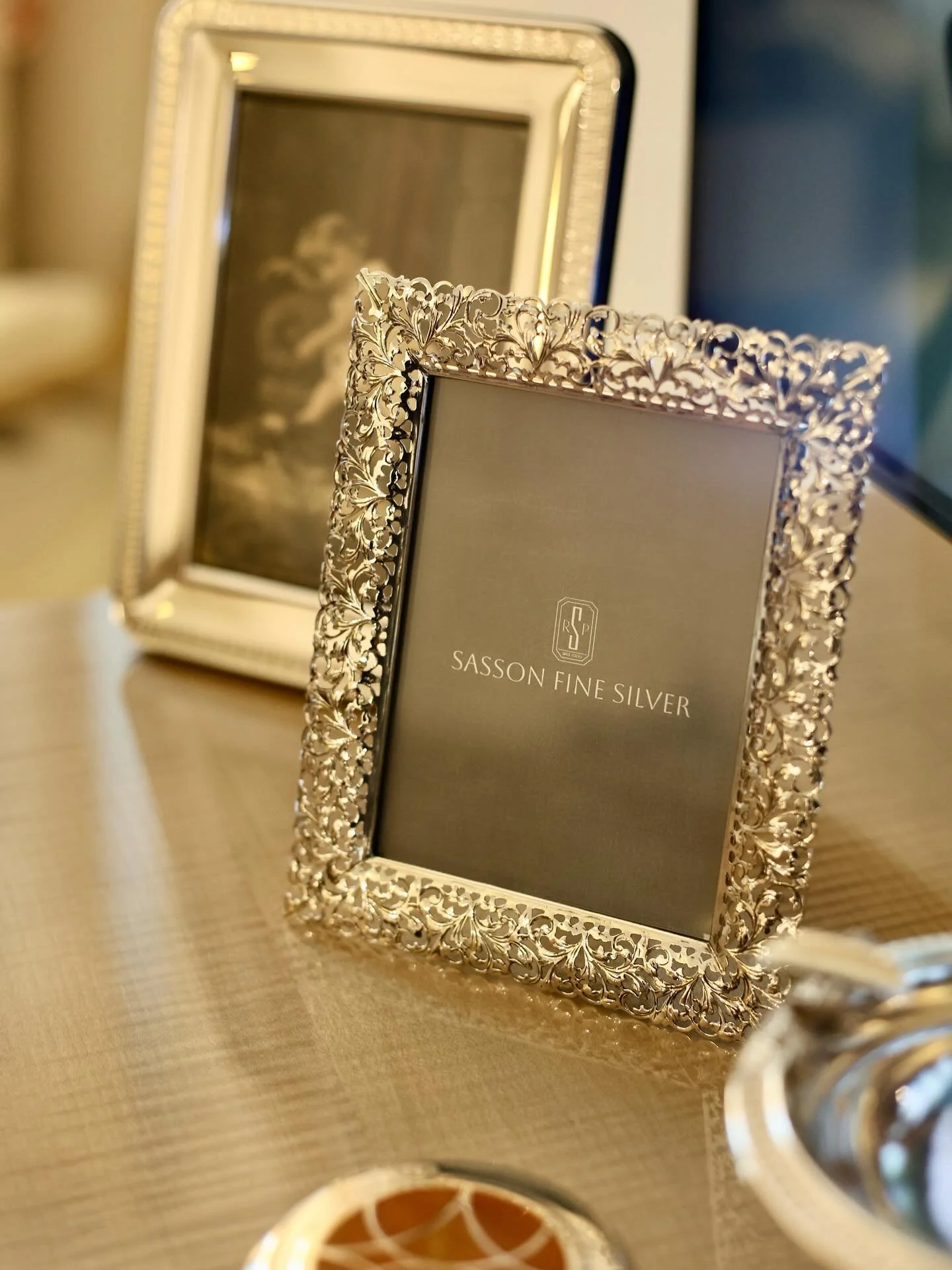 This exquisite sterling silver picture frame showcases an ornate reticulated border, skillfully crafted to highlight timeless beauty and fine detail. The openwork design adds a touch of sophistication, allowing light to play through the delicate silv