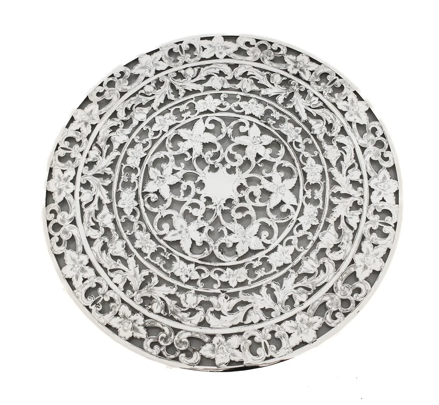 This exquisite sterling silver overlay trivet dates to the turn of the 20th century and remains in mint condition. The piece features an elaborate and finely detailed overlay design, likely applied over glass, showcasing the ornate aesthetic popular 