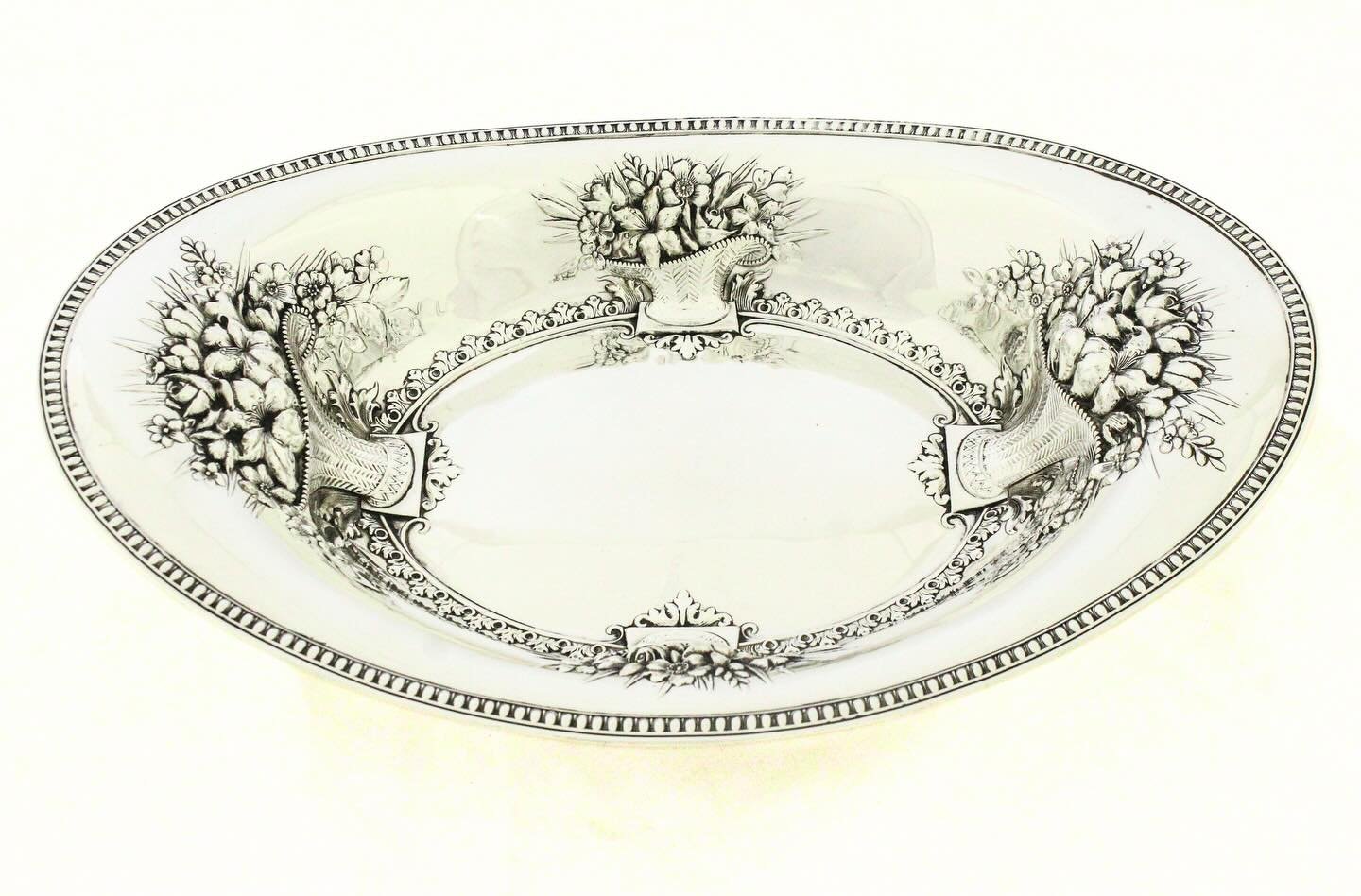 An exceptional sterling silver breadbasket by the Whiting Manufacturing Company, dated 1909, showcasing the firm&rsquo;s mastery of repouss&eacute; and chased silverwork during the Edwardian era.
Of oval form, the basket features a broad, gently curv