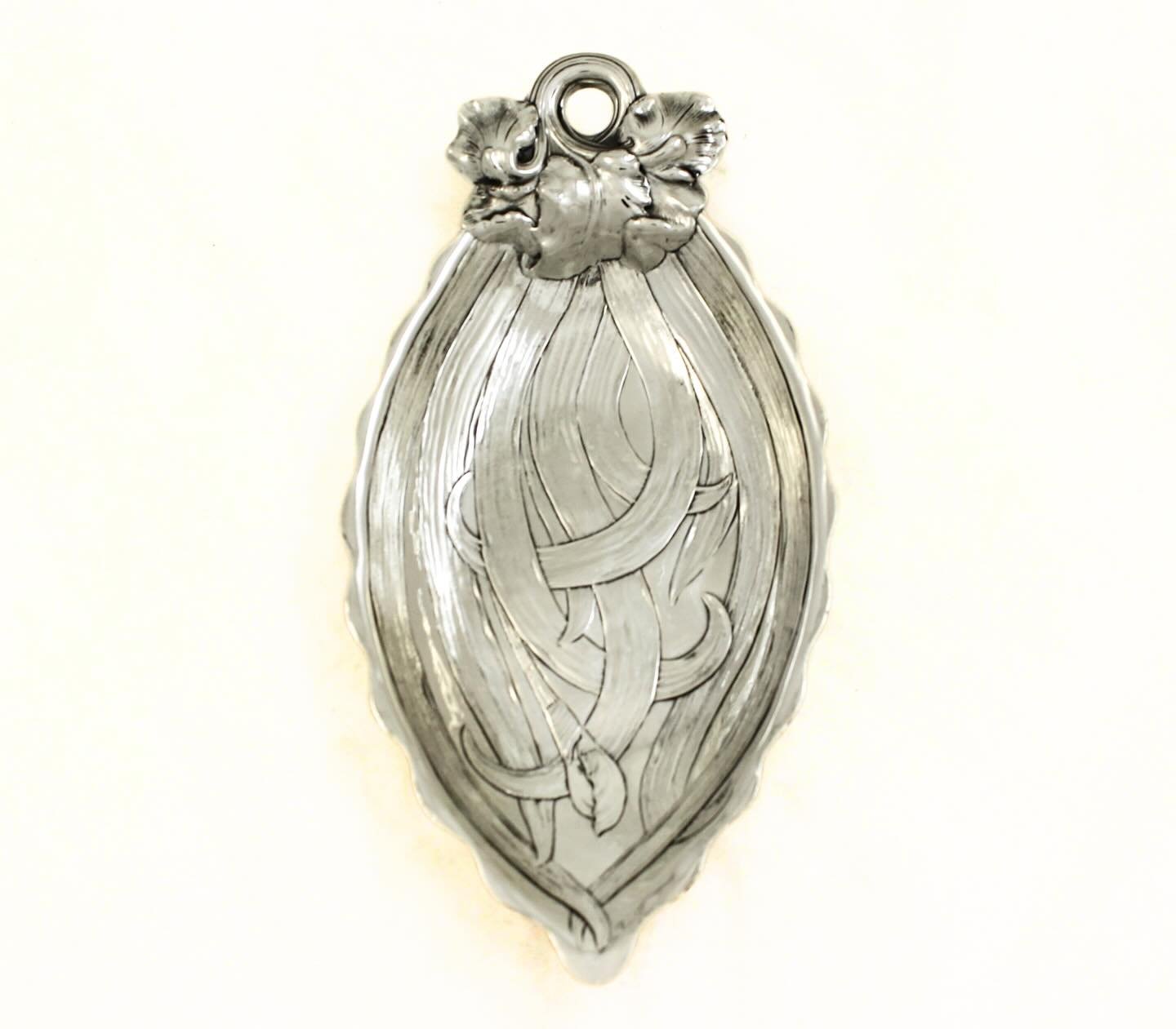 Art Nouveau at its finest.
This exceptional sterling silver dish by Gorham Silversmiths embodies the flowing, organic lines that defined the turn of the 20th century. Graceful, intertwined ribbons sweep across the surface like stylized vines, framed 