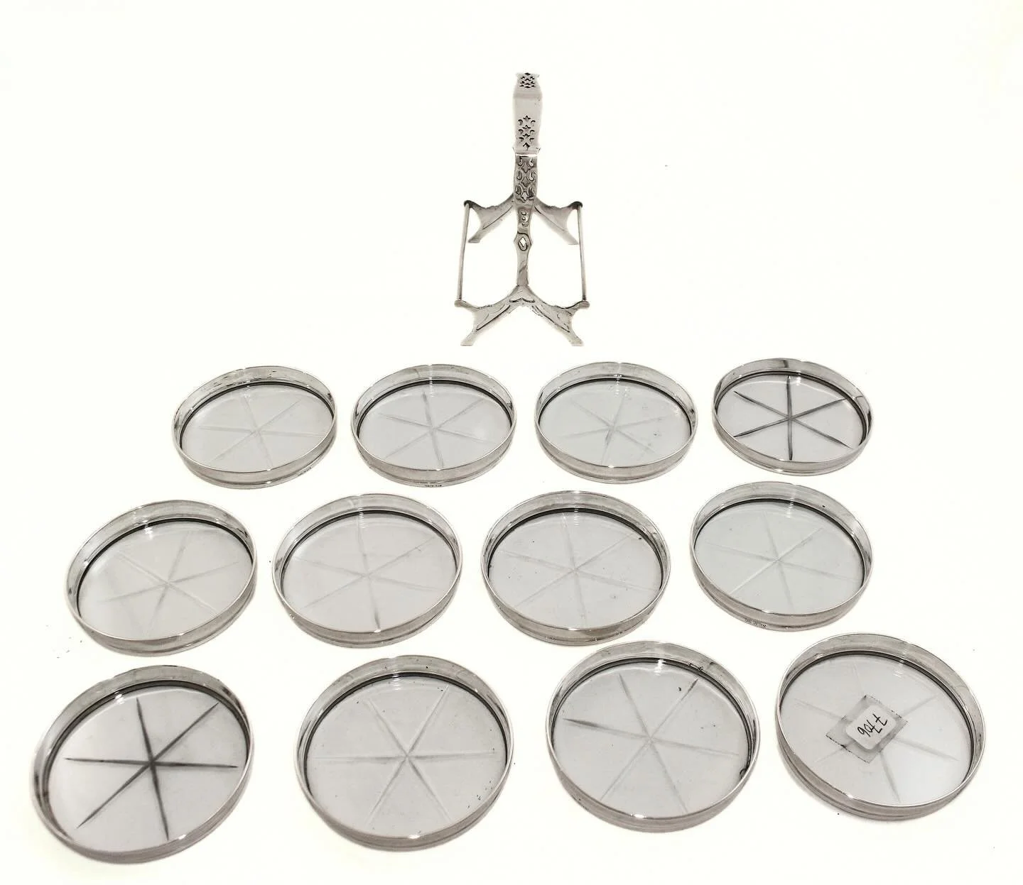 A handsome set of twelve sterling silver coasters housed in their original fitted caddy.

Each coaster is set with glass featuring a classic starburst center &mdash; a detail that catches the light beautifully and protects your table just as well as 