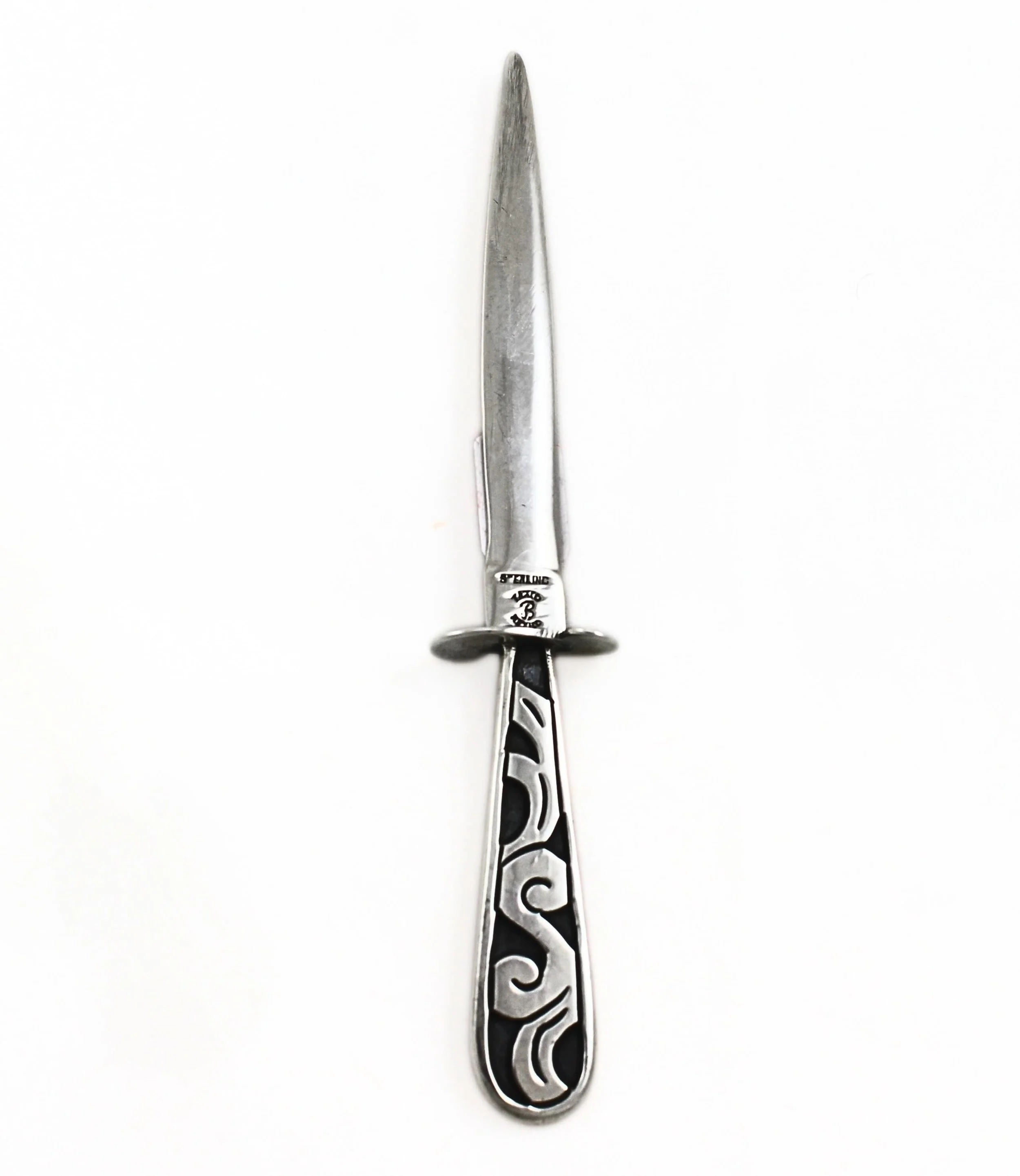 A truly unusual and seldom-seen piece of sterling silver craftsmanship. This rare sterling silver letter opener features a striking modernist design with bold scrolling decoration set against a dramatic oxidized background, creating a beautiful contr