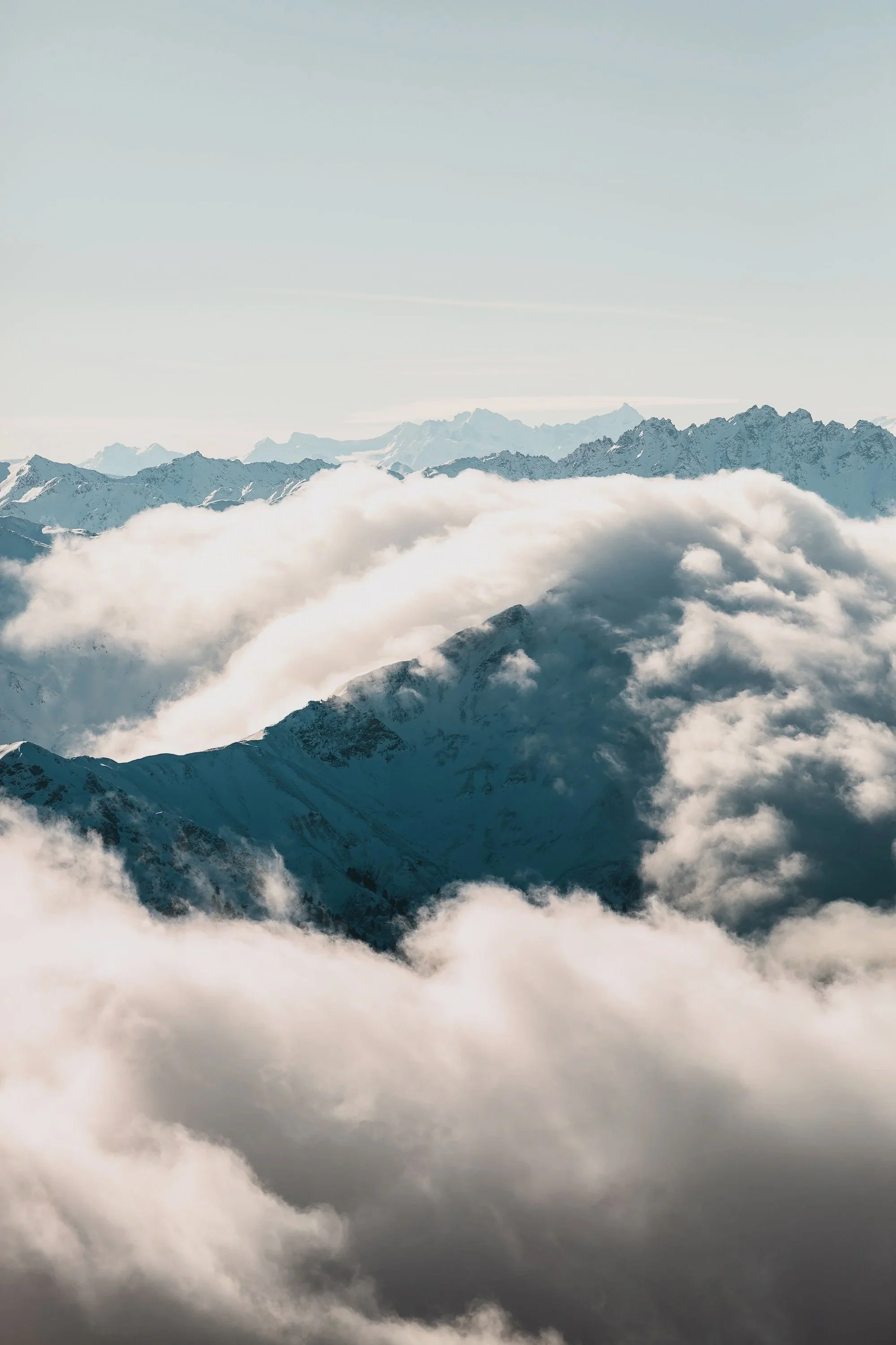 Berggipfel und Wolken über den Bergen im Himmel, verschneite Gipfel, Kalter Himmel