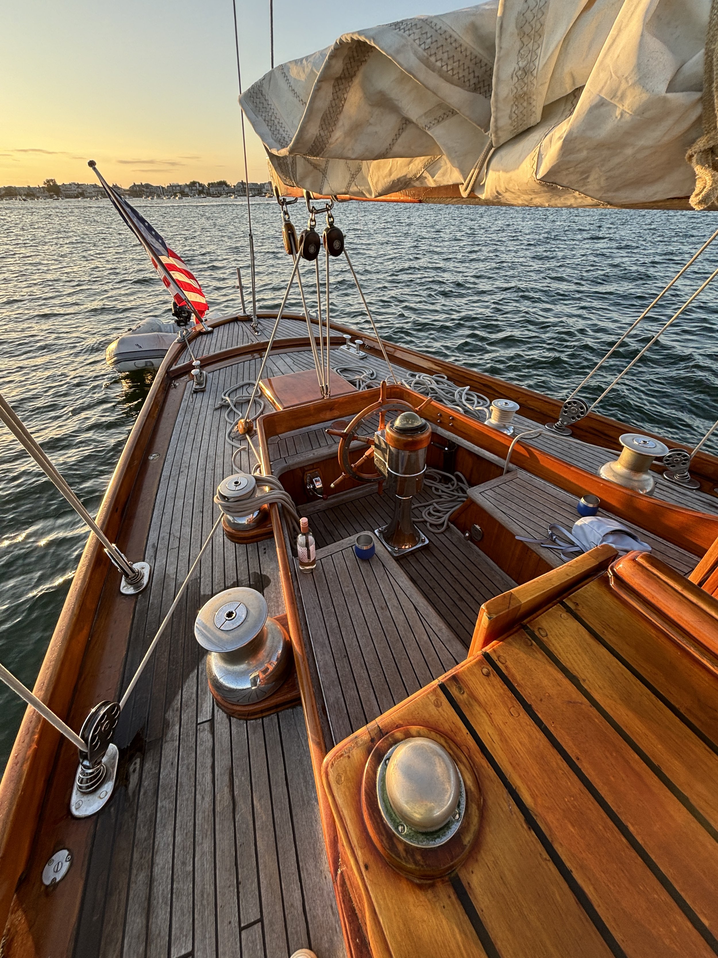 Sailboat deck at sunset with folded sails and American flag