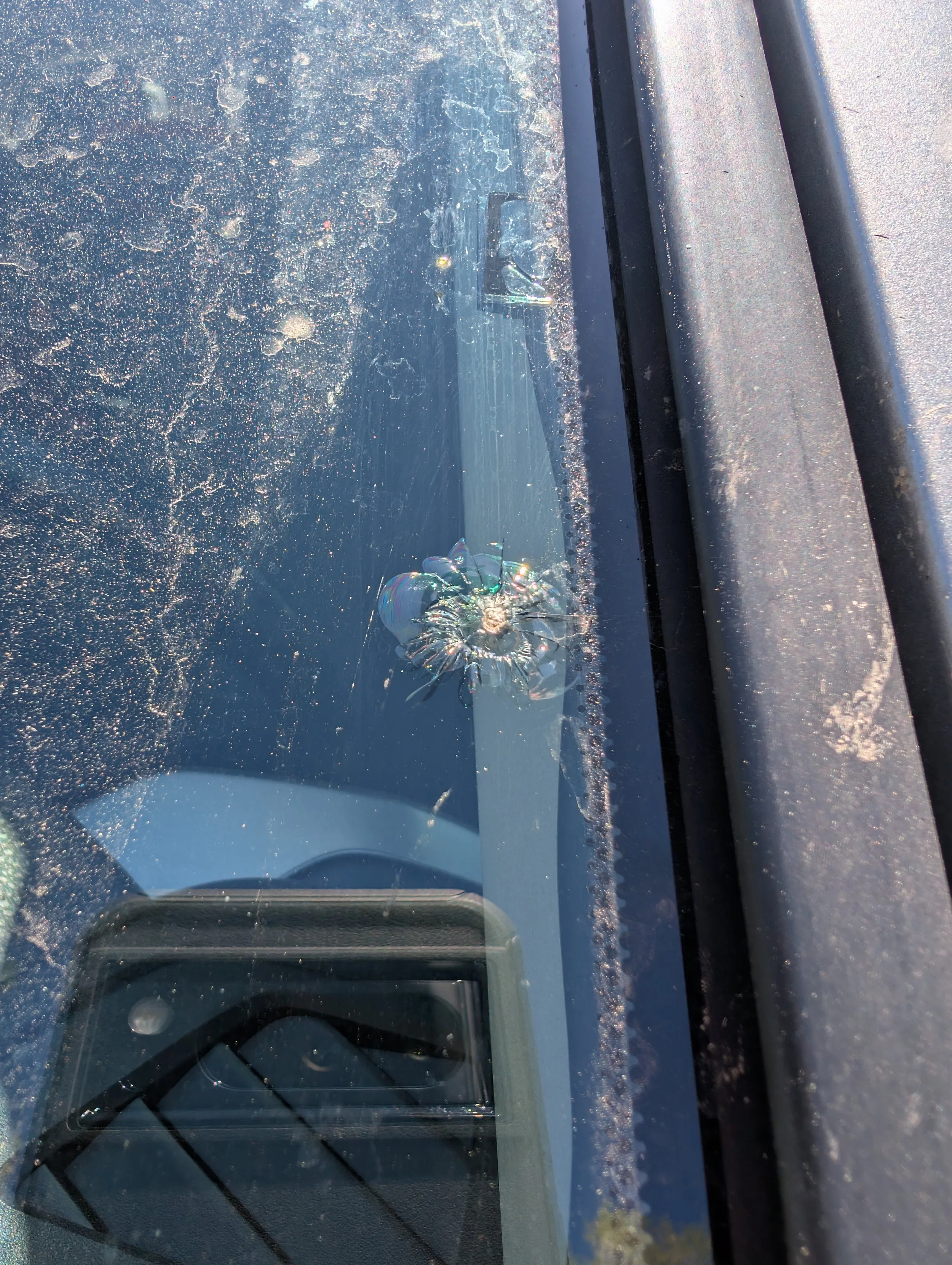 Close-up of rock chip damage on a windshield of a vehicle.