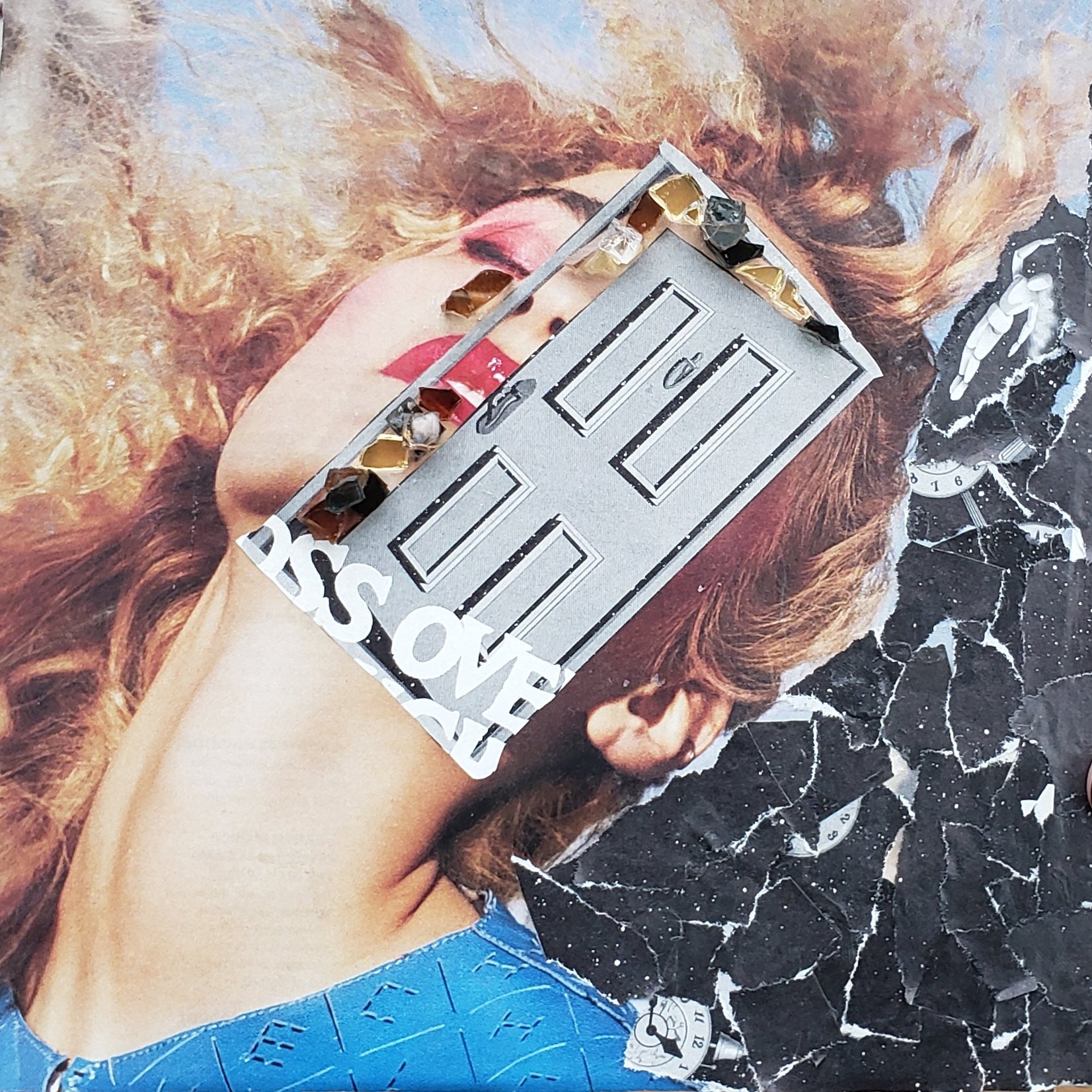 A magazine page featuring a woman with red curly hair and pink lipstick. A silver decorative piece with black, white, and gold stones is resting on her face. The background has a black and white marble pattern with small clock illustrations.