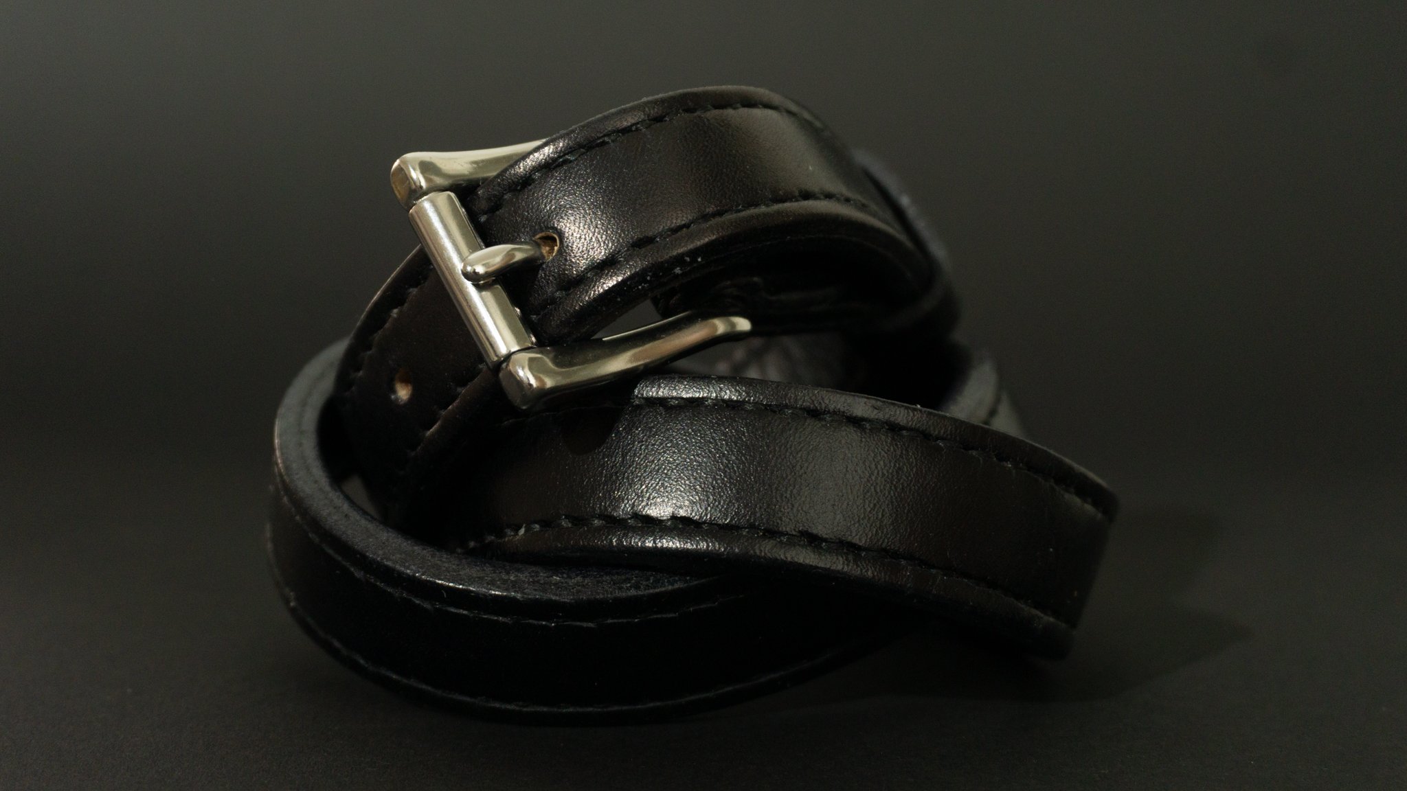 Belt.
A stainless-steel roller buckle, with two hand-sewn layers of black-stained 3.5mm veg-tan leather, creating a highly resilient and durable belt. Despite its robust construction, its sleek design and narrow width allow for a more elegant look.
