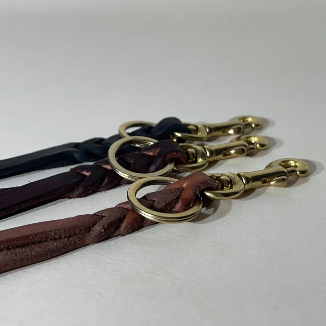 Keychains.
Braided piece of 2,4-2,6 mm veg. tanned, with a small brass snap hook and split ring.