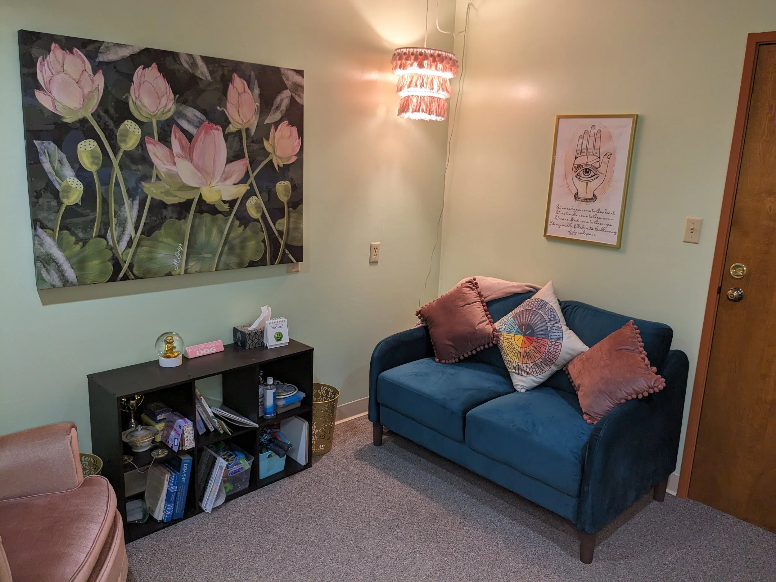 low-light therapy room with teal velvet loveseat and soft furnishings designed for neurodivergent clients in Olathe Kansas