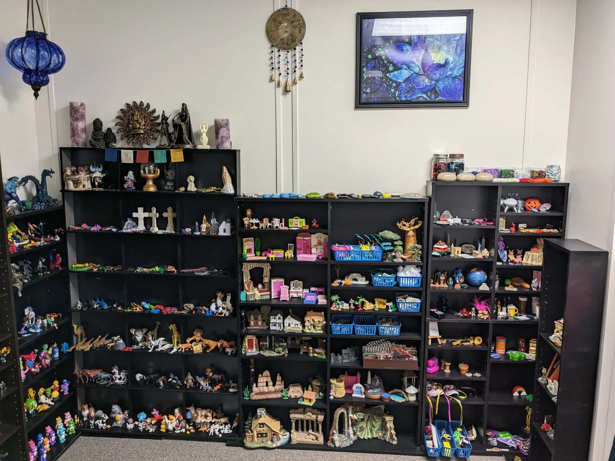 A room with shelves filled with toy miniatures for sandtray expressive therapy to help therapy clients express and process in Olathe Kansas