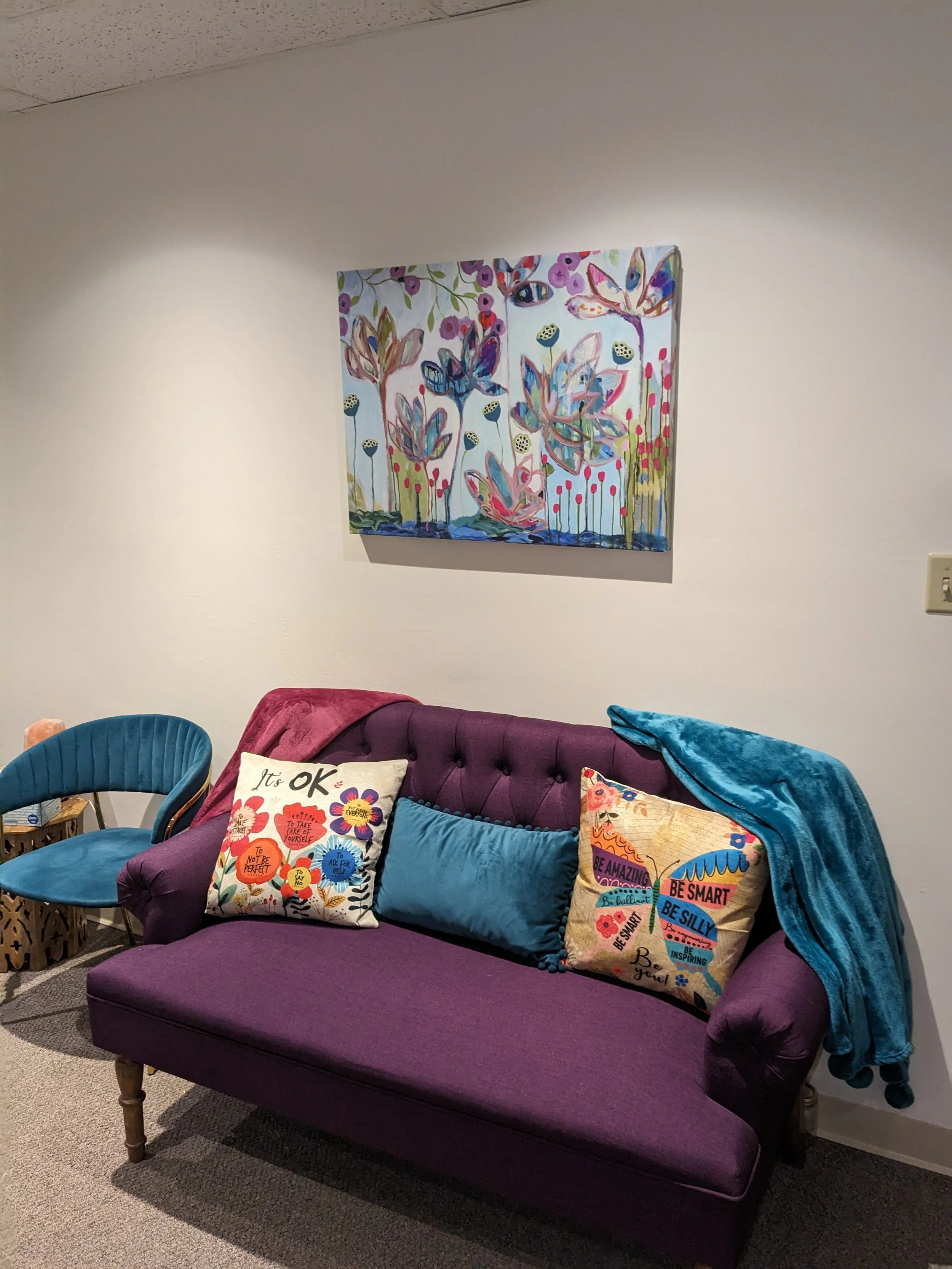 :ow-light therapy waiting room with purple settee and soft pillows for neurodivergent clients in Olathe Kansas