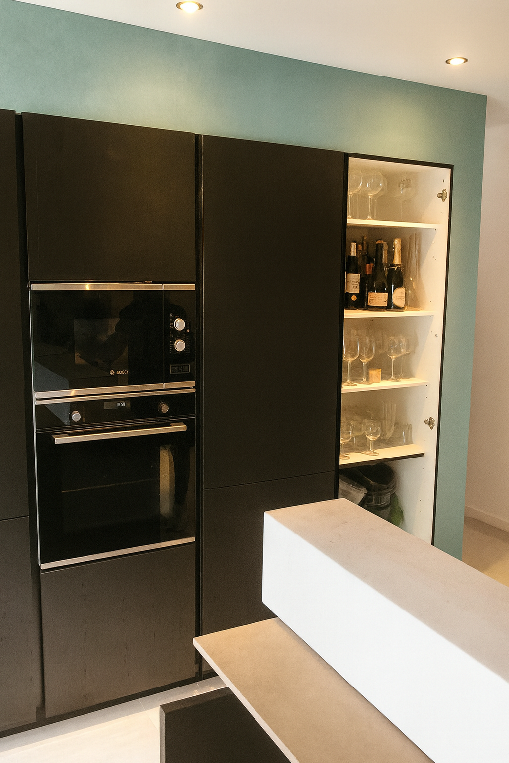 Cuisine sombre minimaliste : Façades noires mates avec niches rétroéclairées pour un rendu contemporain.