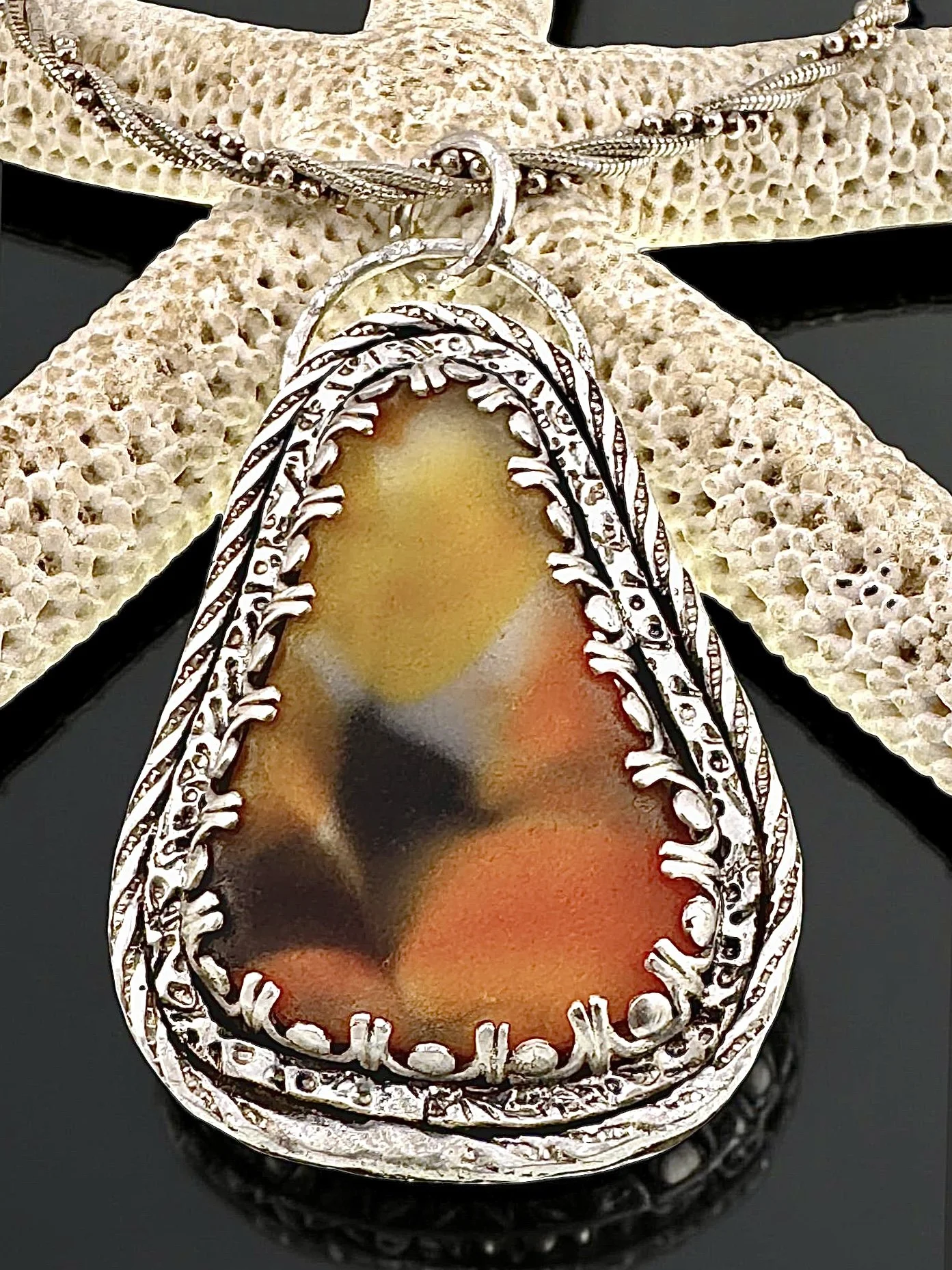 Murano Seaglass pendant surrounded by three layers of decorative sterling silver with patina. 