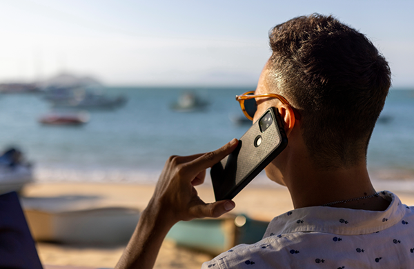 Small business owner answering cell phone at the beach.