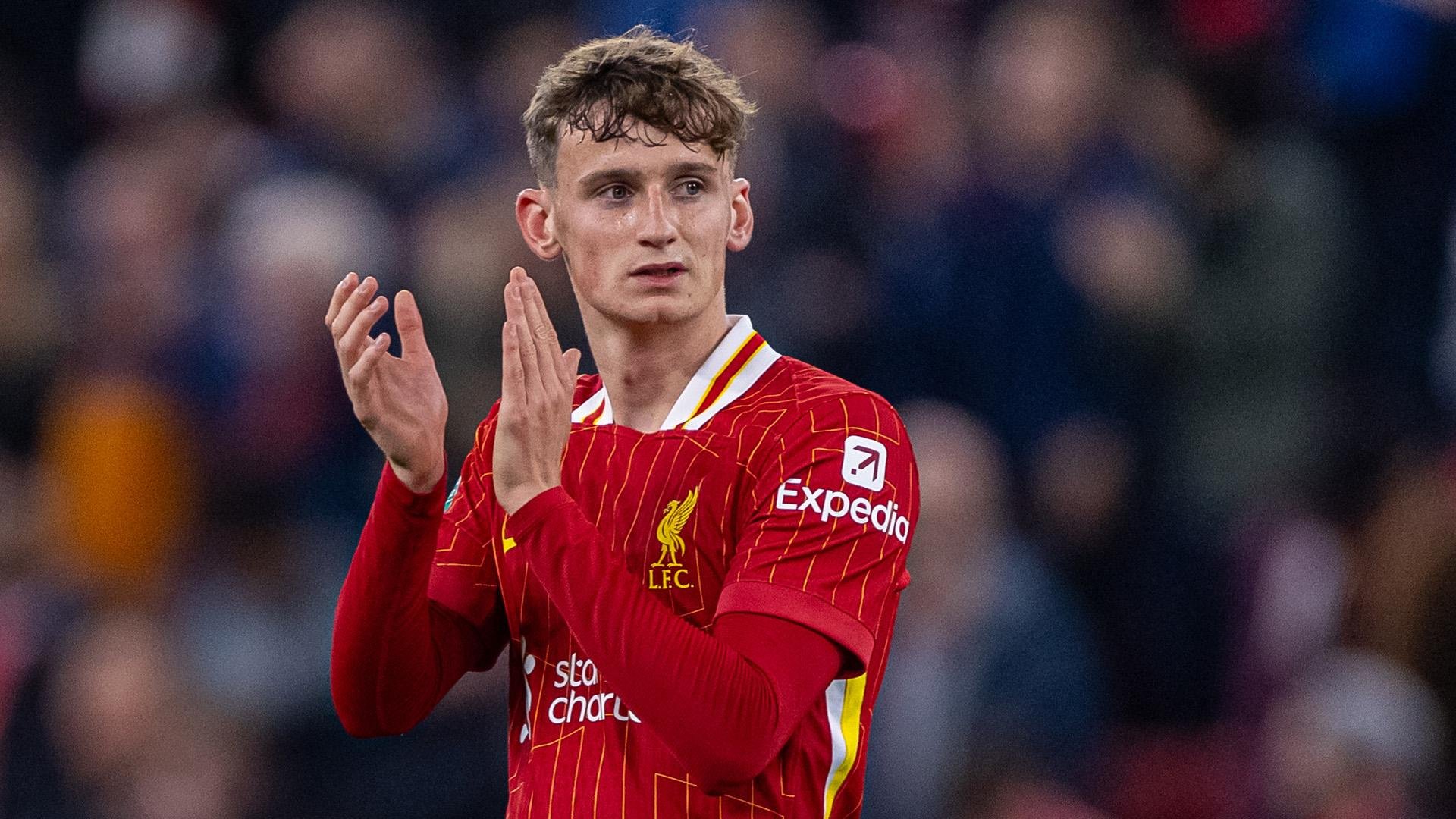 Soccer player in red Liverpool FC jersey clapping on field