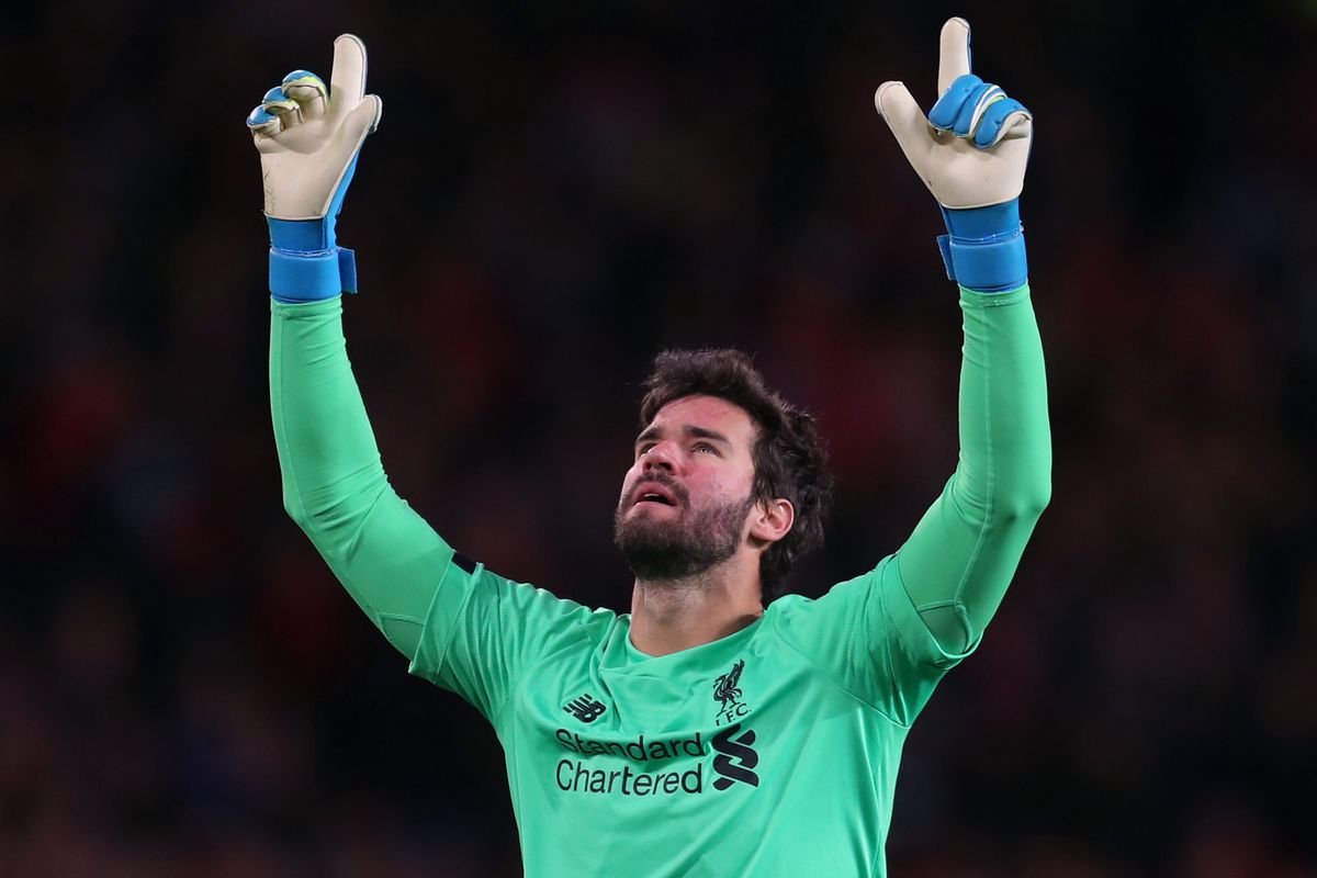 Soccer goalkeeper in green kit pointing upwards