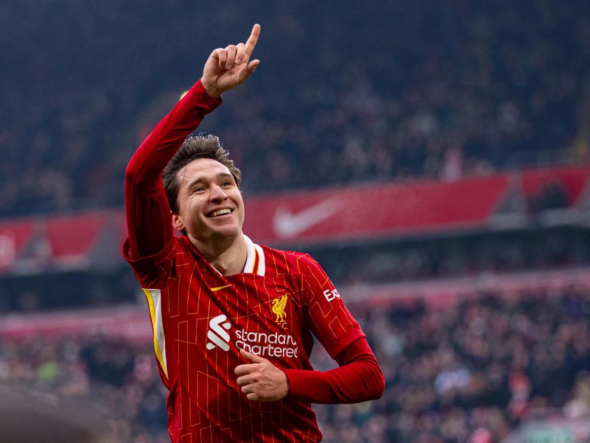 Soccer player in red and white Liverpool jersey celebrating on field