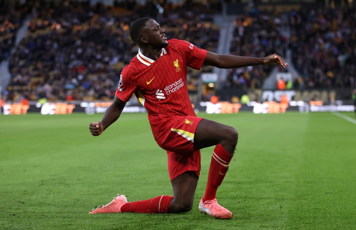 Soccer player in red uniform celebrating on field during match.