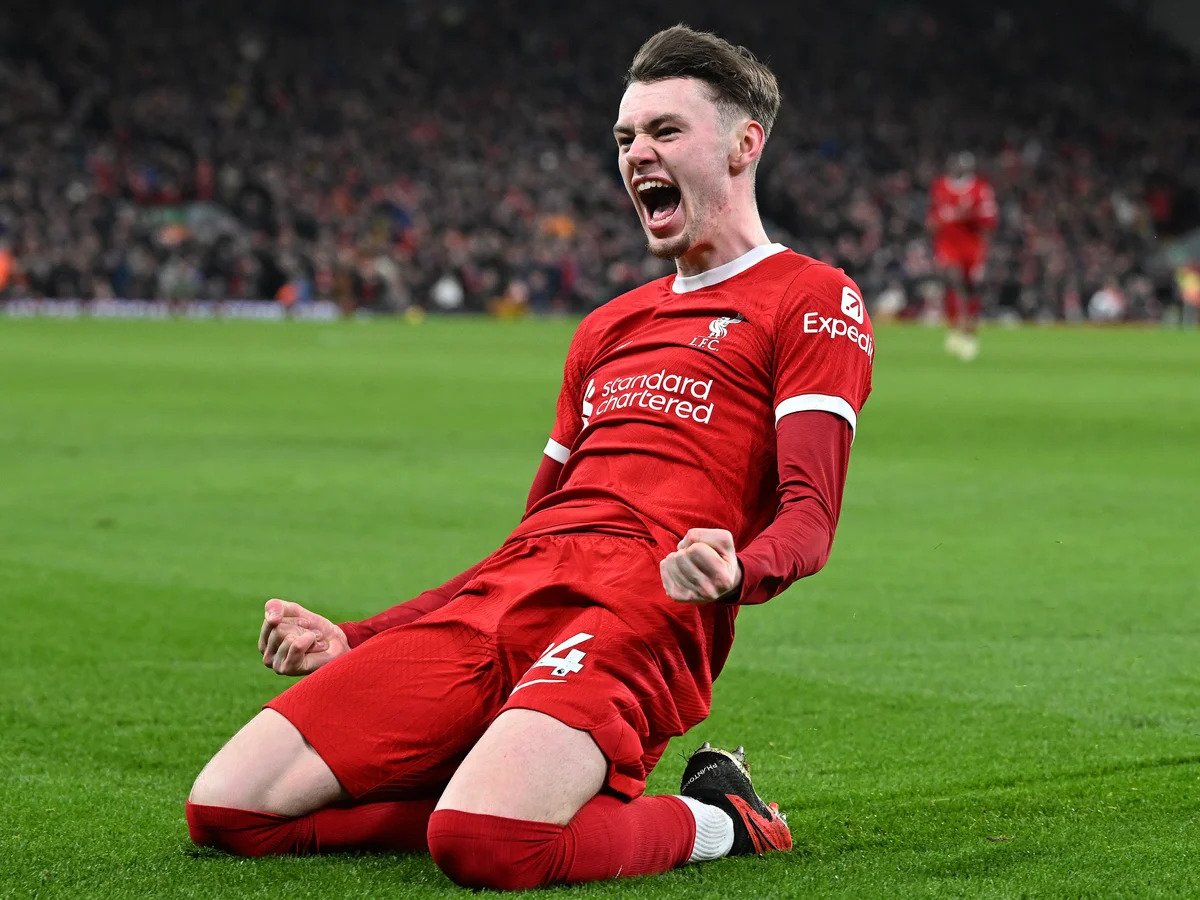 Soccer player in red uniform celebrating goal on the field.