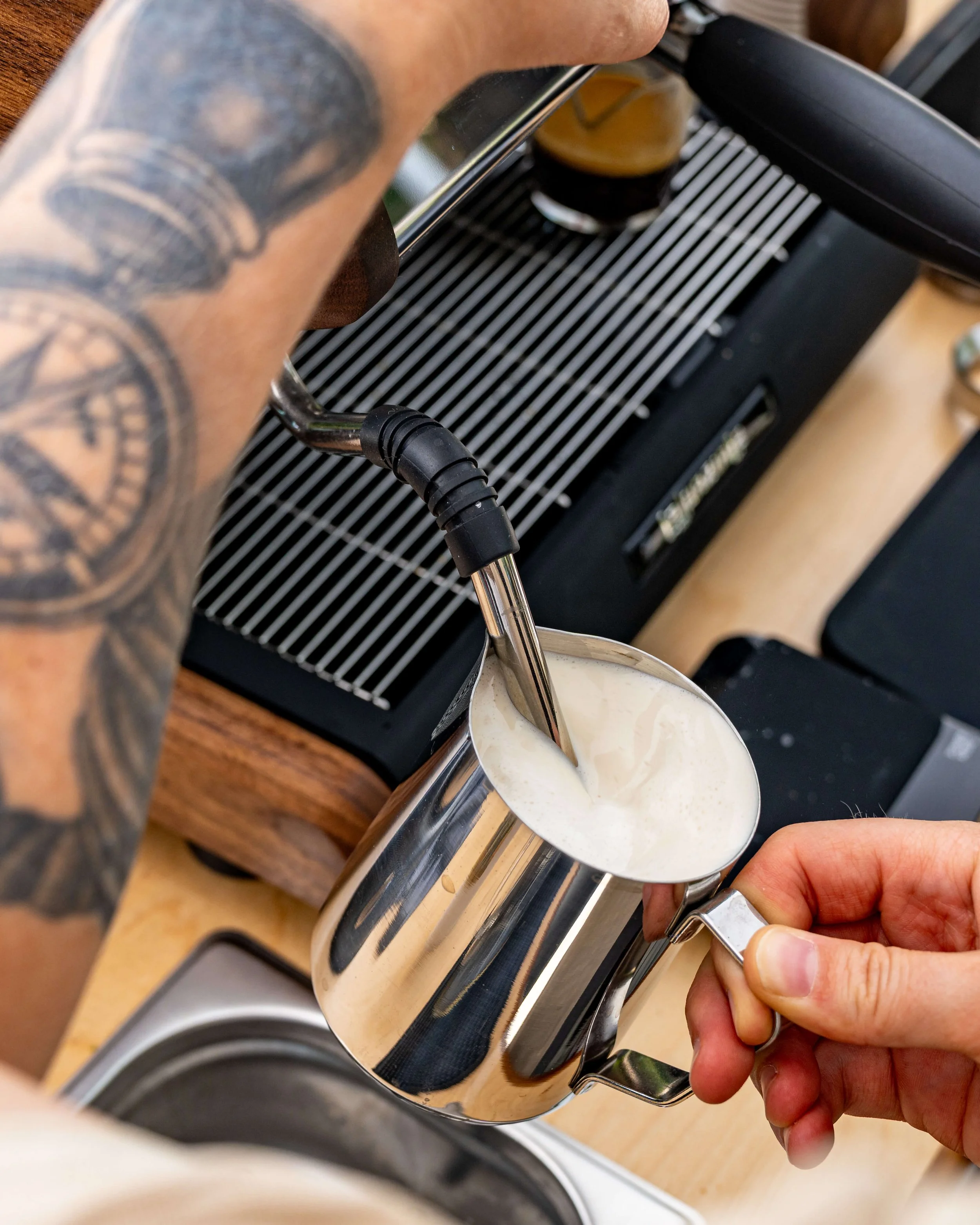 barista steaming milk for a cappuccino