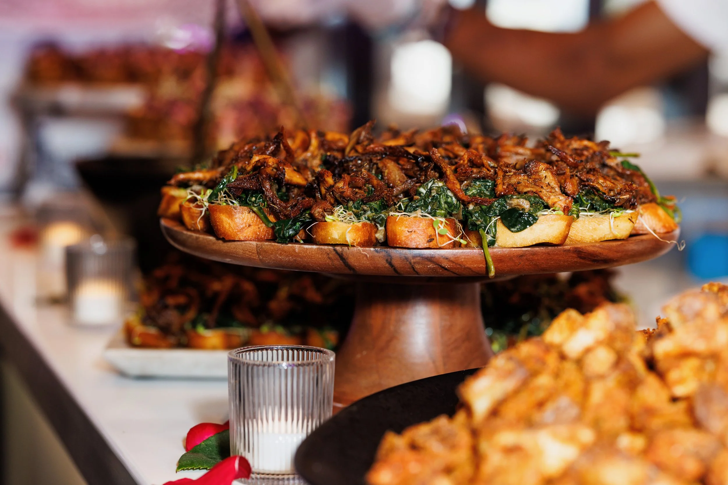 Gourmet appetizers by Gingerbeet Catering artfully arranged by Solari on a raised wooden platter for a Rolls-Royce event.