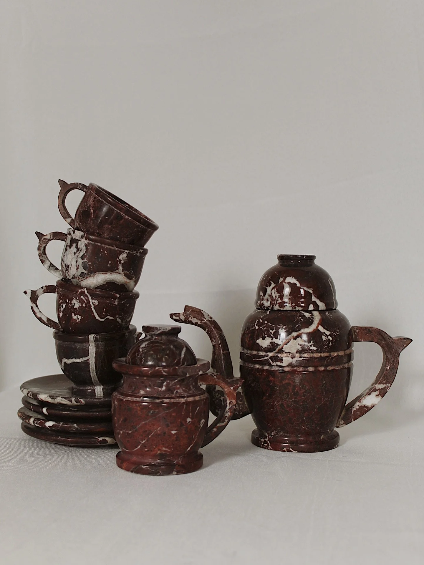 Vintage Rosso Levanto natural marble tea set, set of ten pieces. Set includes four teacups, four saucers, a sugar bowl with lid and a pitcher with a lid. Absolutely ~incredible~ natural veining throughput each piece. Truly a statement, heirloom set.
