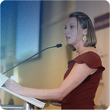 Jennifer Thompson public speaking in a maroon dress
