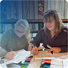 Two women sitting at a table working on growth plans and personal goals
