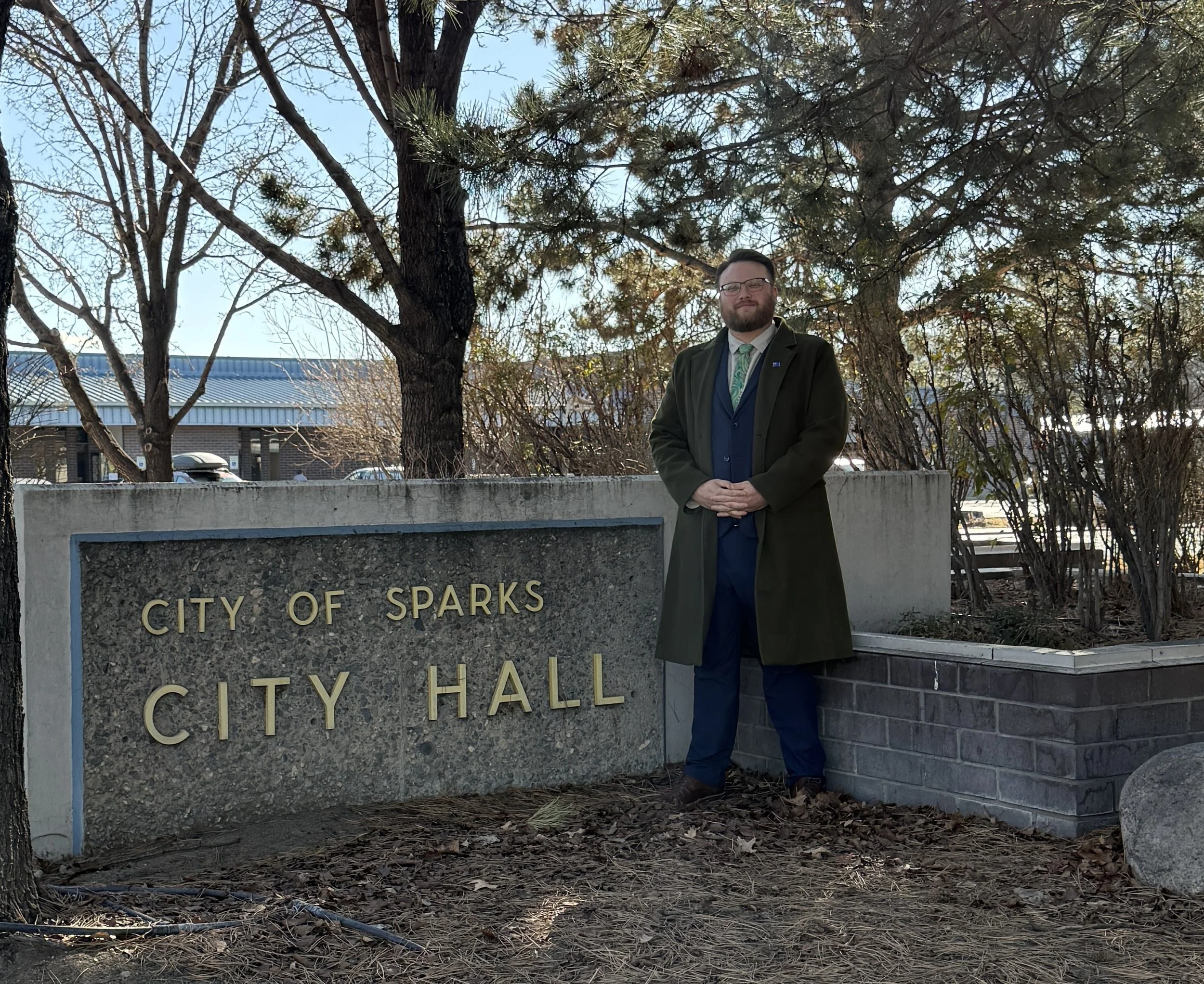 Hunter Rand stands in front of a landmark sign at Sparks City Hall.