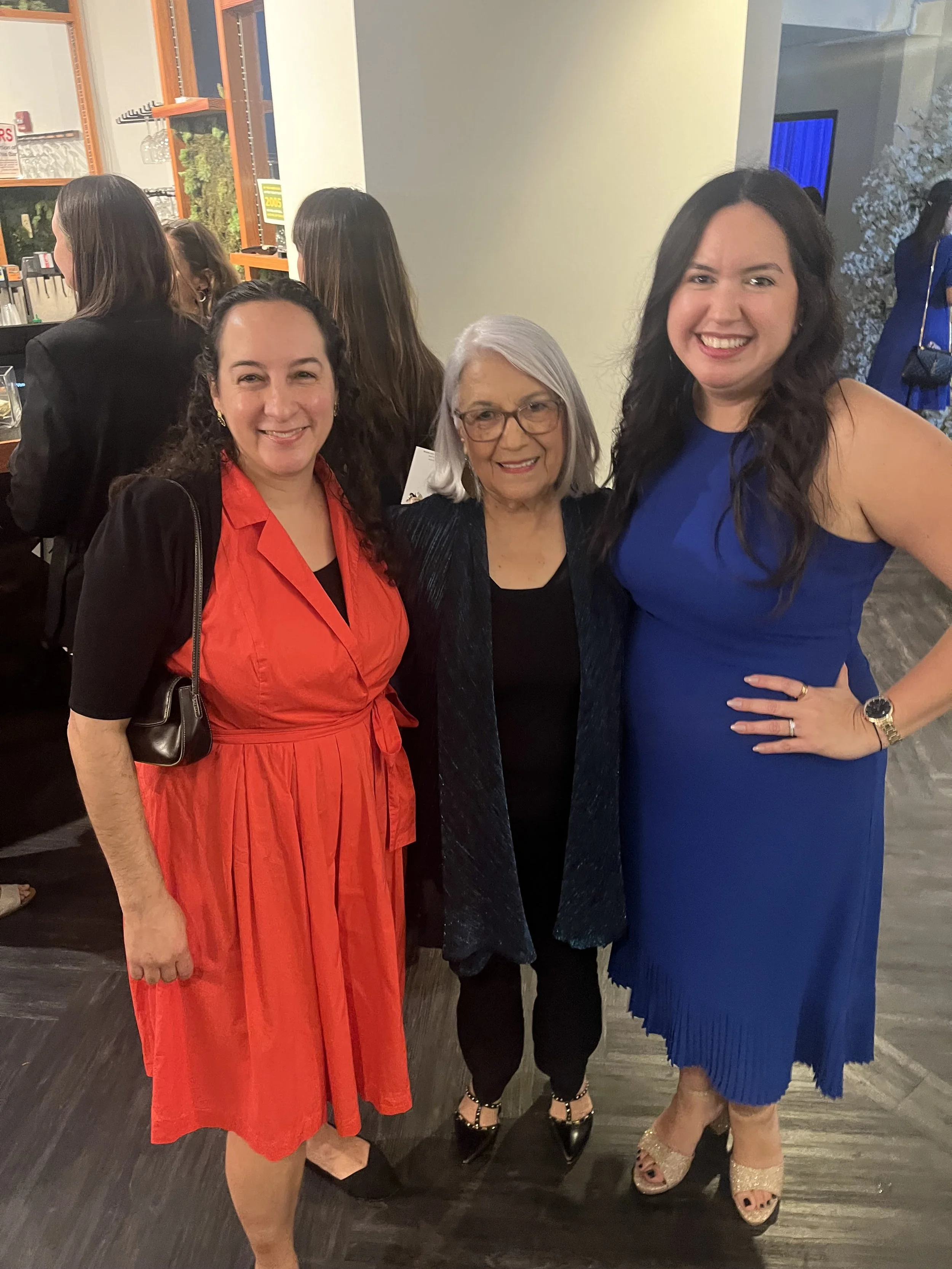 Felicita poses with two other women in formal clothing