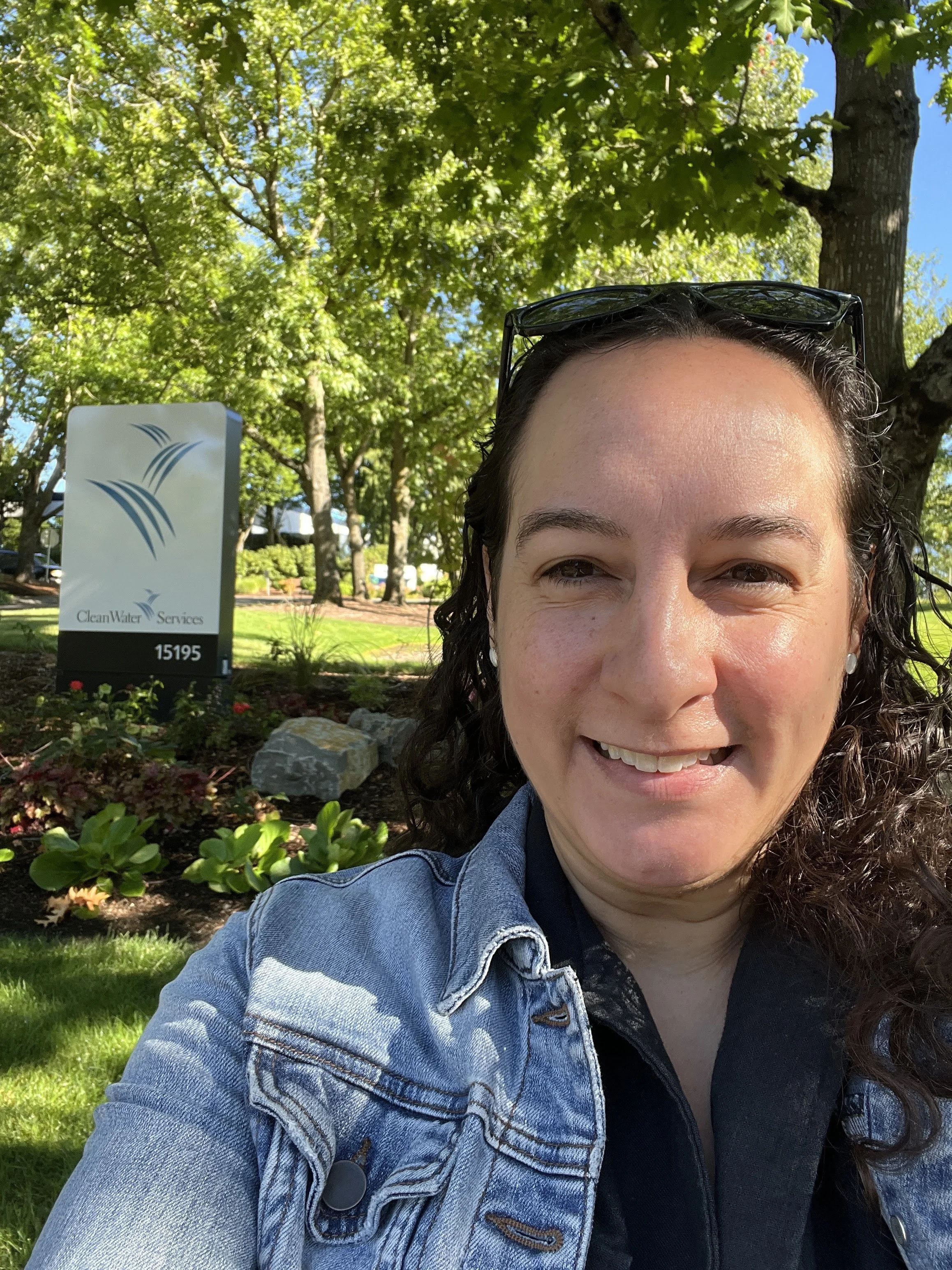 Felicita takes a selfie in front of the CleanWater Services sign