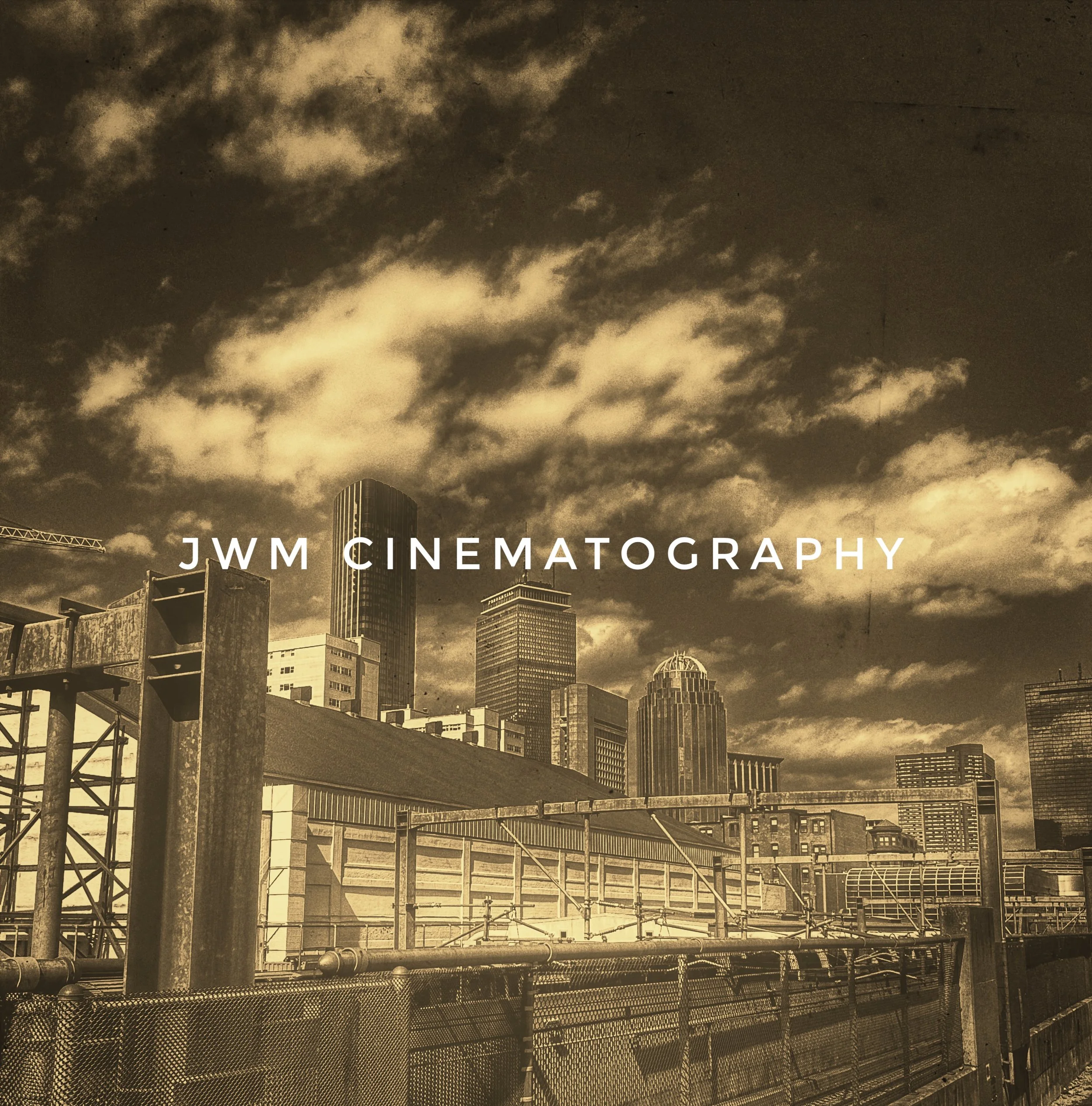 Vintage-style image of a city skyline with skyscrapers under a cloudy sky, featuring the text 'JWM Cinematography.'