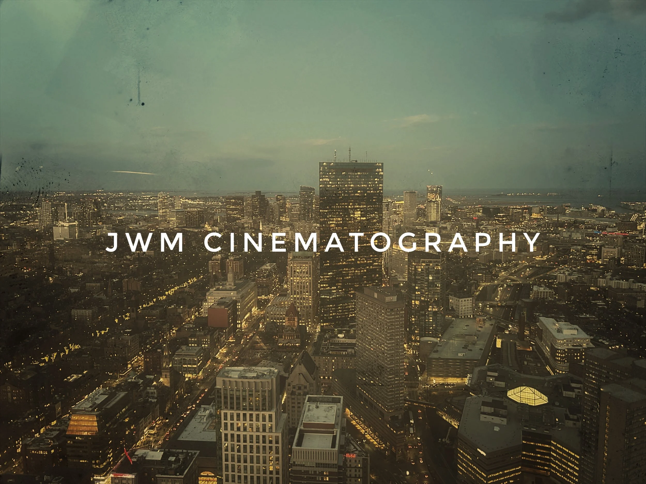 Arial view of city skyline at dusk with the text 'JWM Cinematography' overlaying the image.