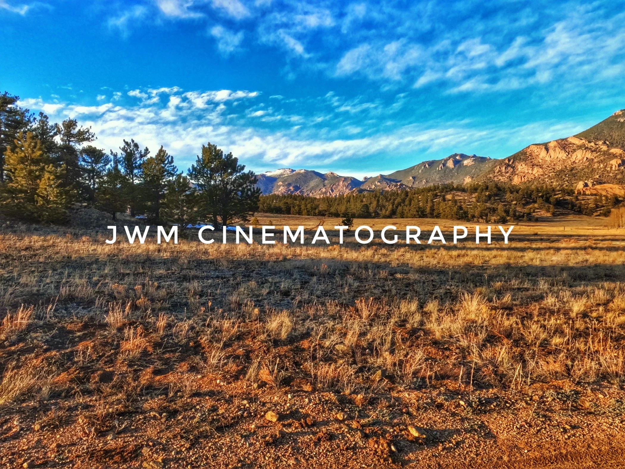 Mountain landscape with blue sky, trees, and "JWM Cinematography" text.