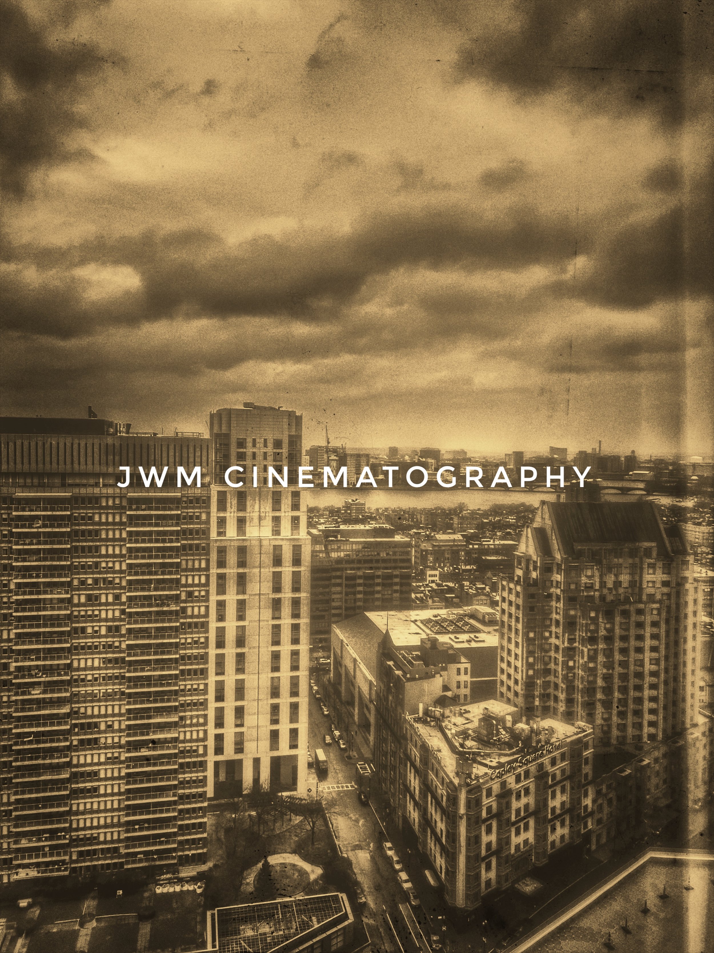 A sepia-toned cityscape featuring tall buildings under a cloudy sky, with "JWM Cinematography" text overlay.
