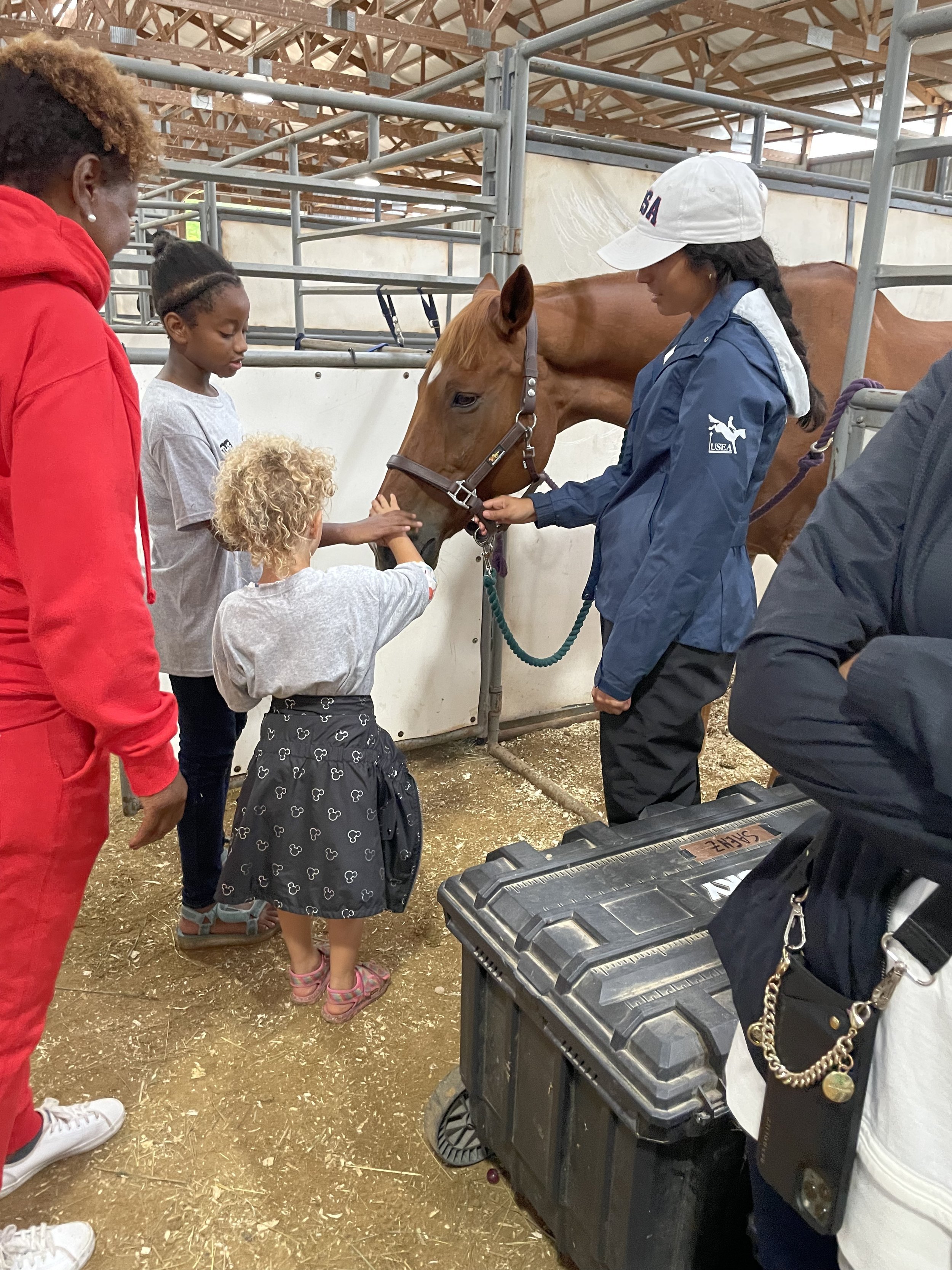 People petting a horse in a stable.
