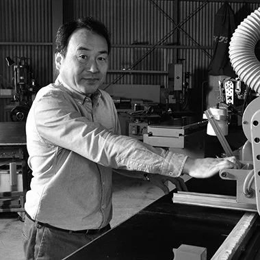 A man operating industrial machinery in a workshop.